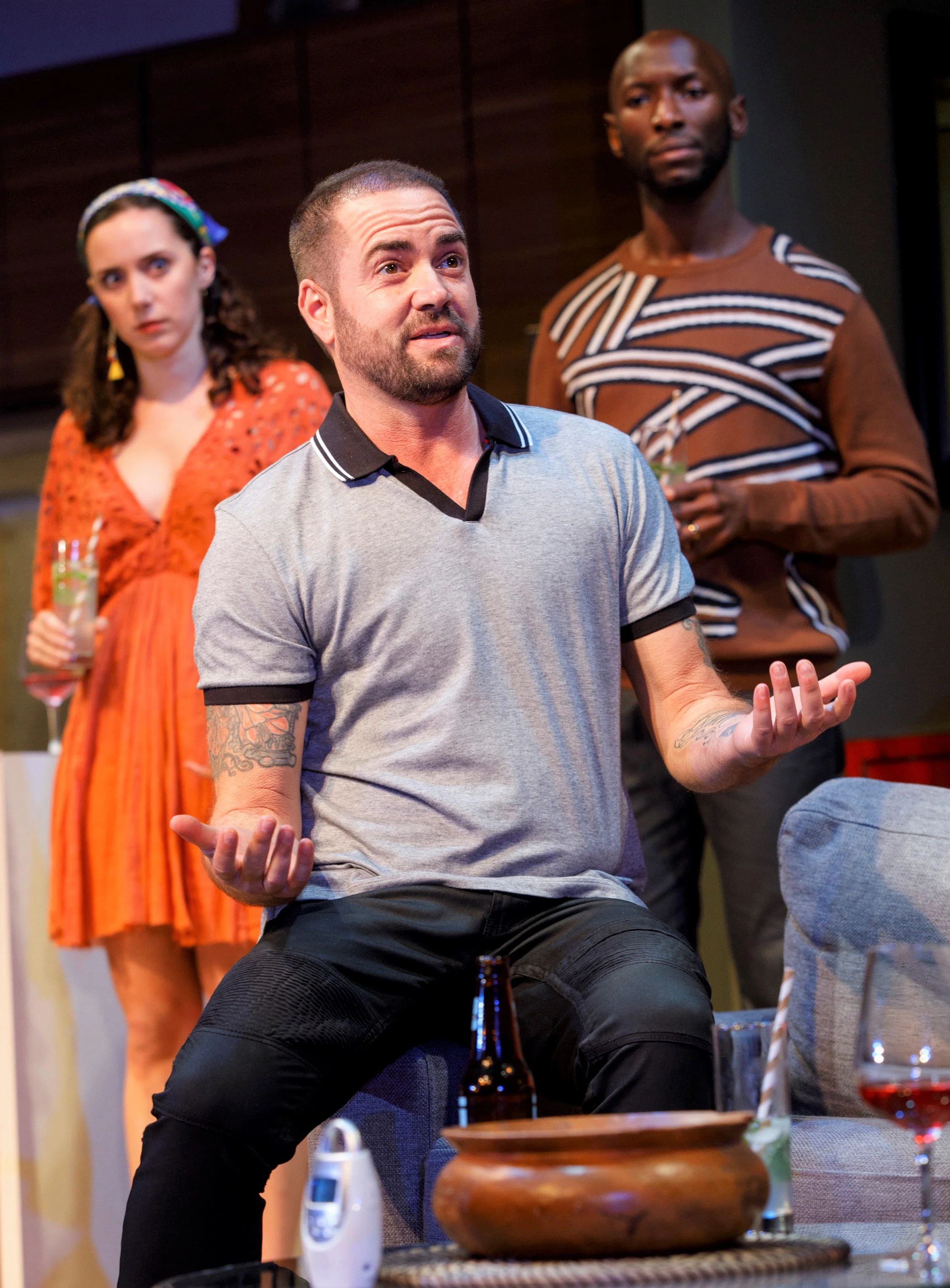 Henry (Harvie) expounds at a cocktail party as Chris and Myna (Talene Monahon), Henry’s girlfriend, look on.