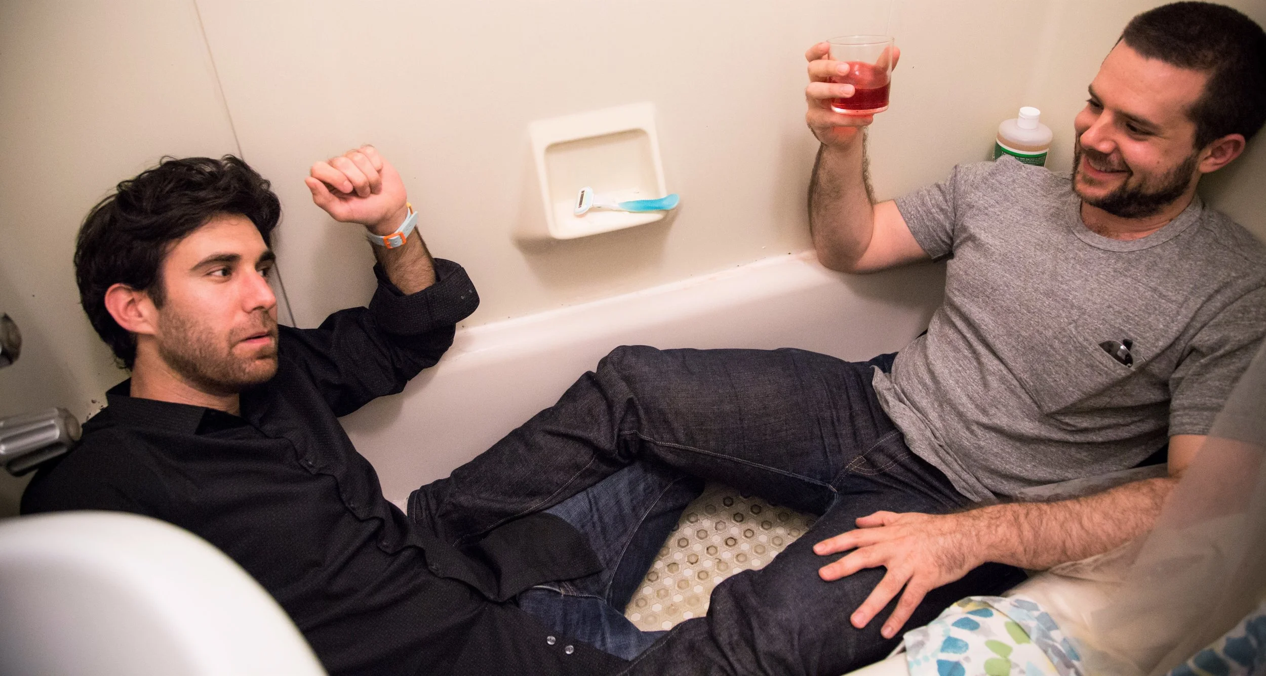 Strangers having a heart-to-heart in the bathtub as their chosen characters in This Is When We Rest . Top: Participants imbibe at the “end of the world party.” Photographs by Natalia Yandyganova.