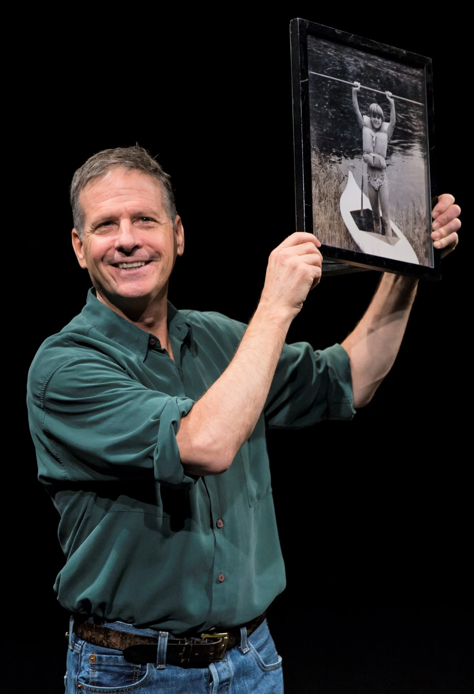 Martin Moran displays a photograph of himself at age 12 that was taken by camp counselor Bob. Top: Moran addresses the audience in the Barrow Group revival of The Tricky Part .