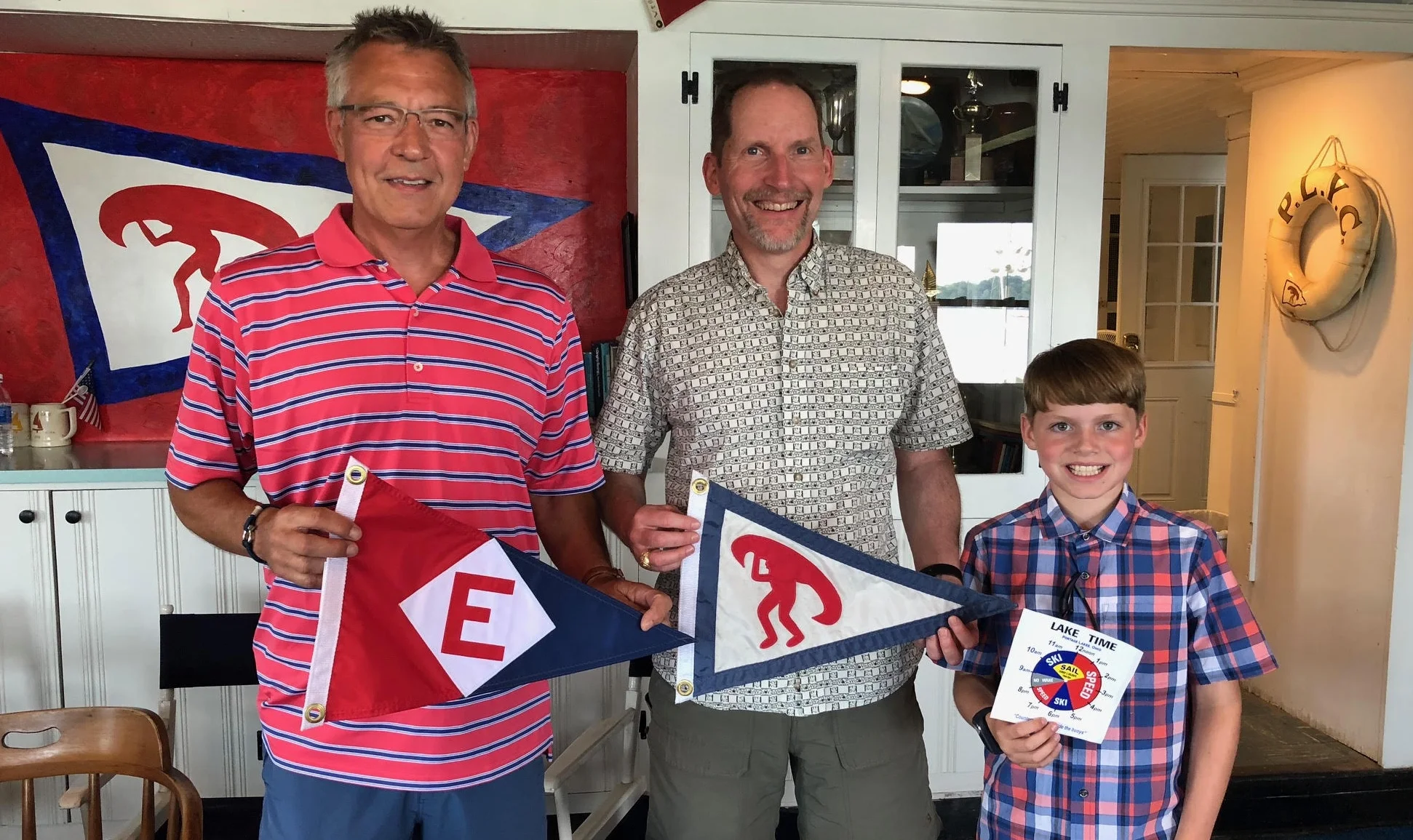 Eric DeFreest (center) and son Nicolai exchange burgees with the Commodore of the Portage Lake Yacht Club in Akron, OH.