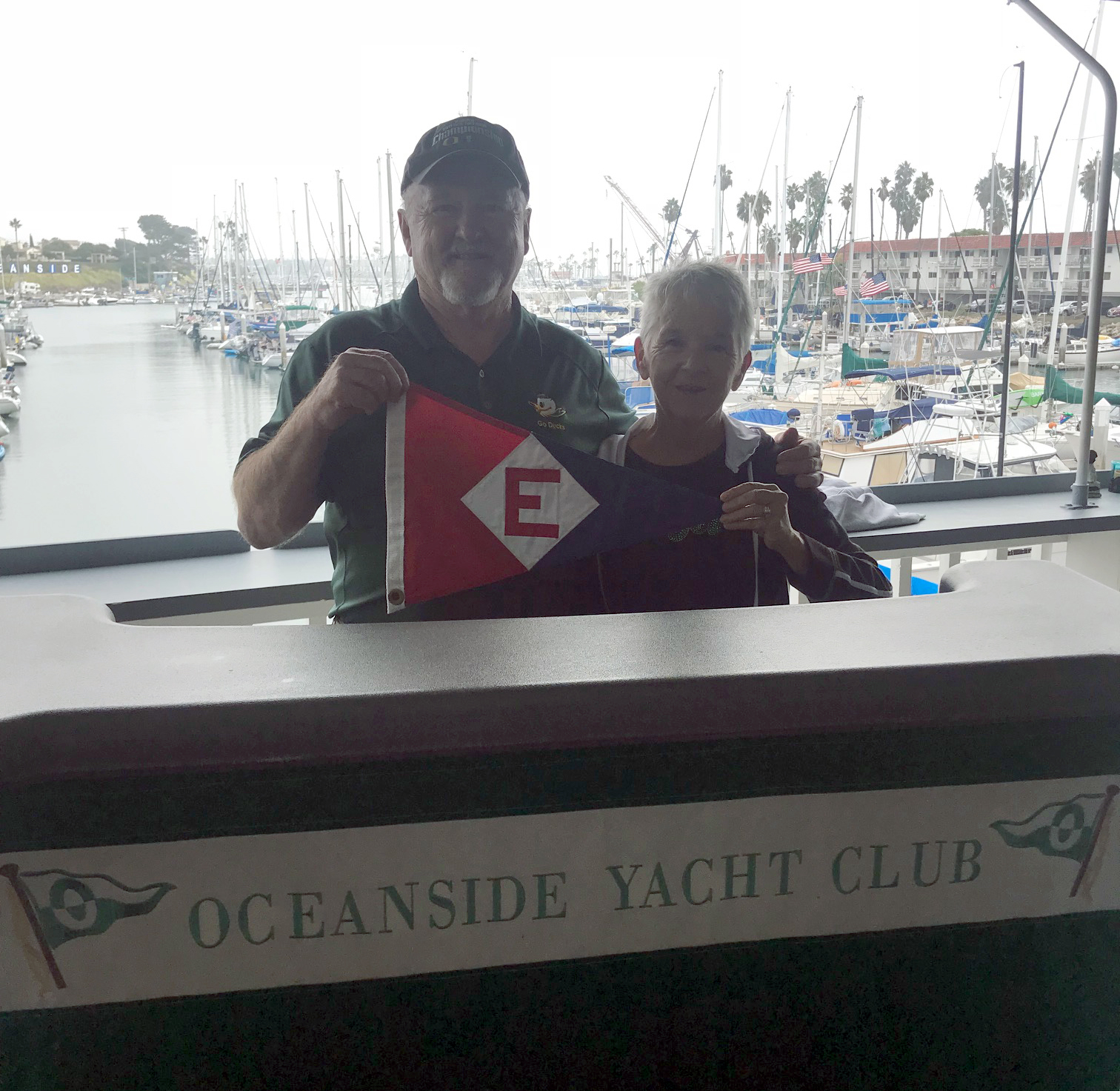  Rex and Bonnie hoist the colors at the Oceanside Yacht Club bar. 