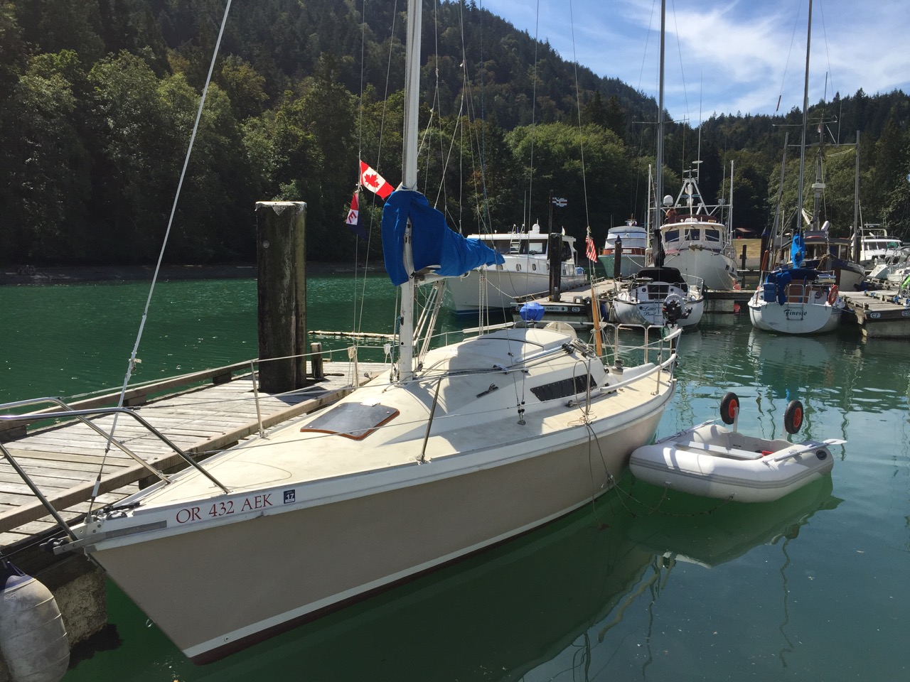 Bob Swangard hoists the colors on his boat Cygnet while at Bowen Island, British Columbia.