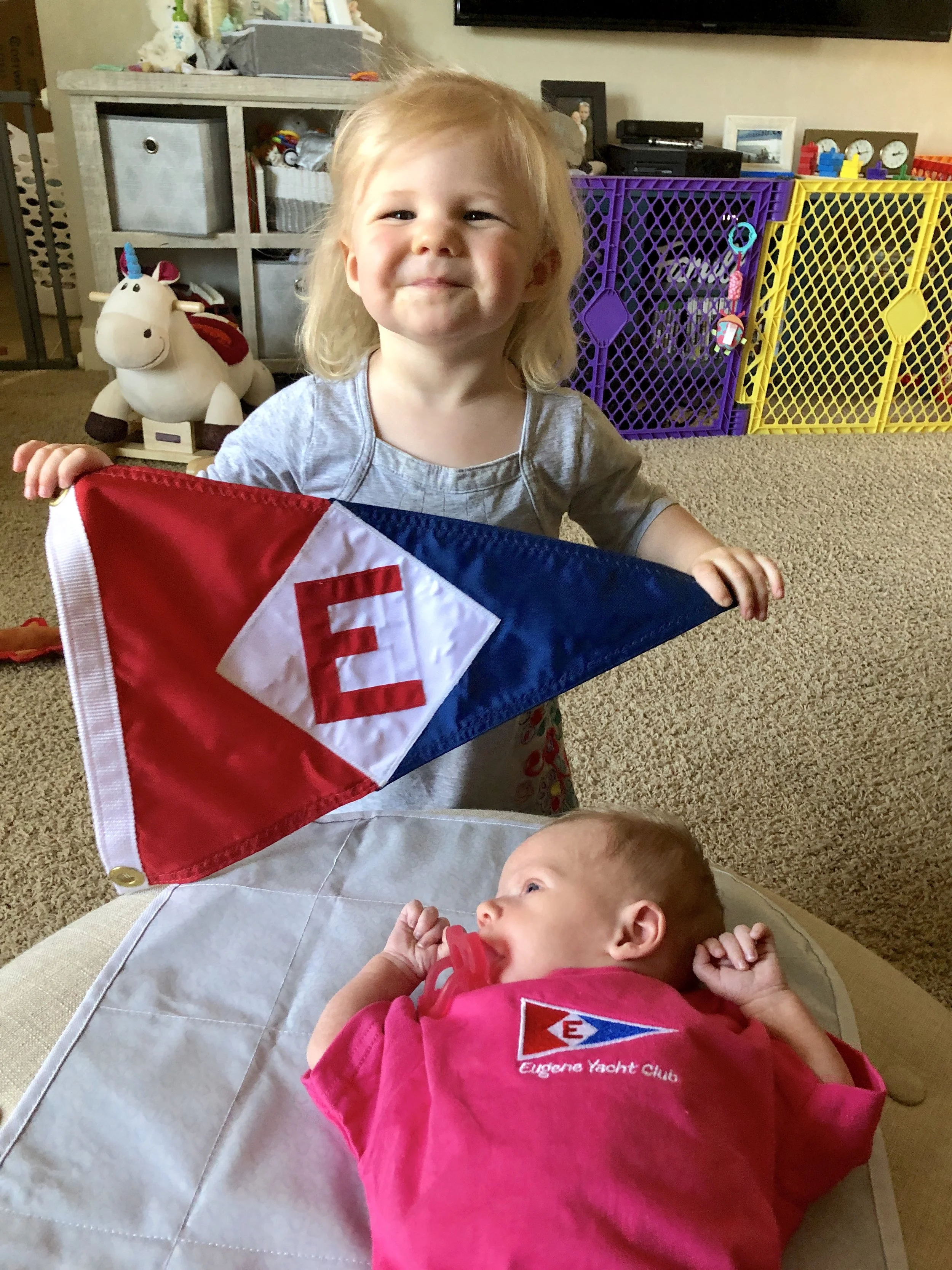Zoey shows off her EYC burgee and her new little sister Natalie at home in Cottage Grove, Oregon.
