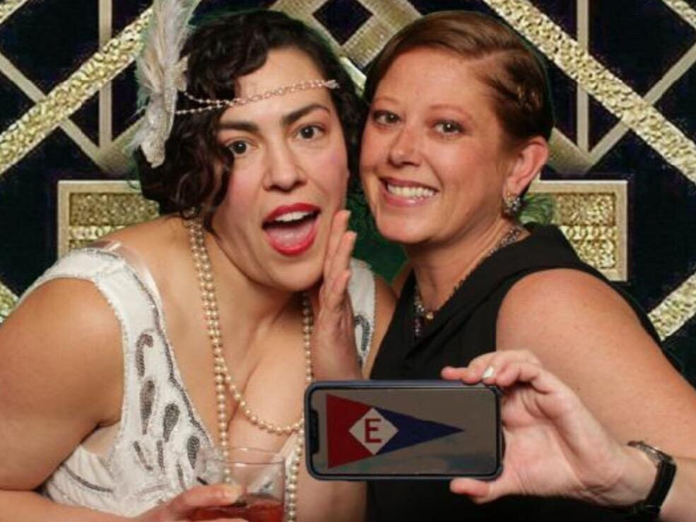  Stephanie and Katie hoist an electronic burgee at a dress-up fundraiser 