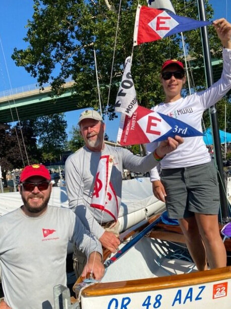  Bryce, Chip, and Greta hoist the colors at the 2021 Thistle National Championships in Cleveland, Ohio 