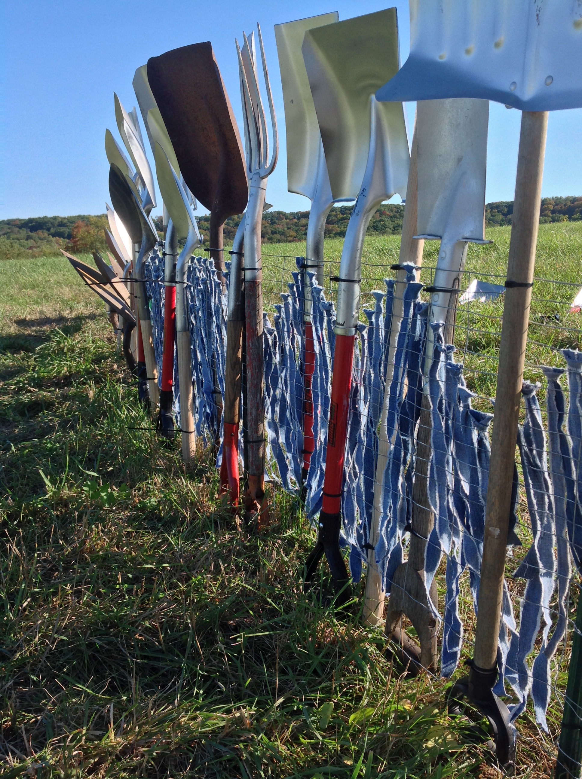  2013  Site specific temporary installation as part of Fermentaion Fest's Farm Art D-tour in Reedsburg, WI.  Approximately 500 shovels to make a 125 foot fence. Denim for tithing was donated, added by viewers.  Photography by author and by Florence K