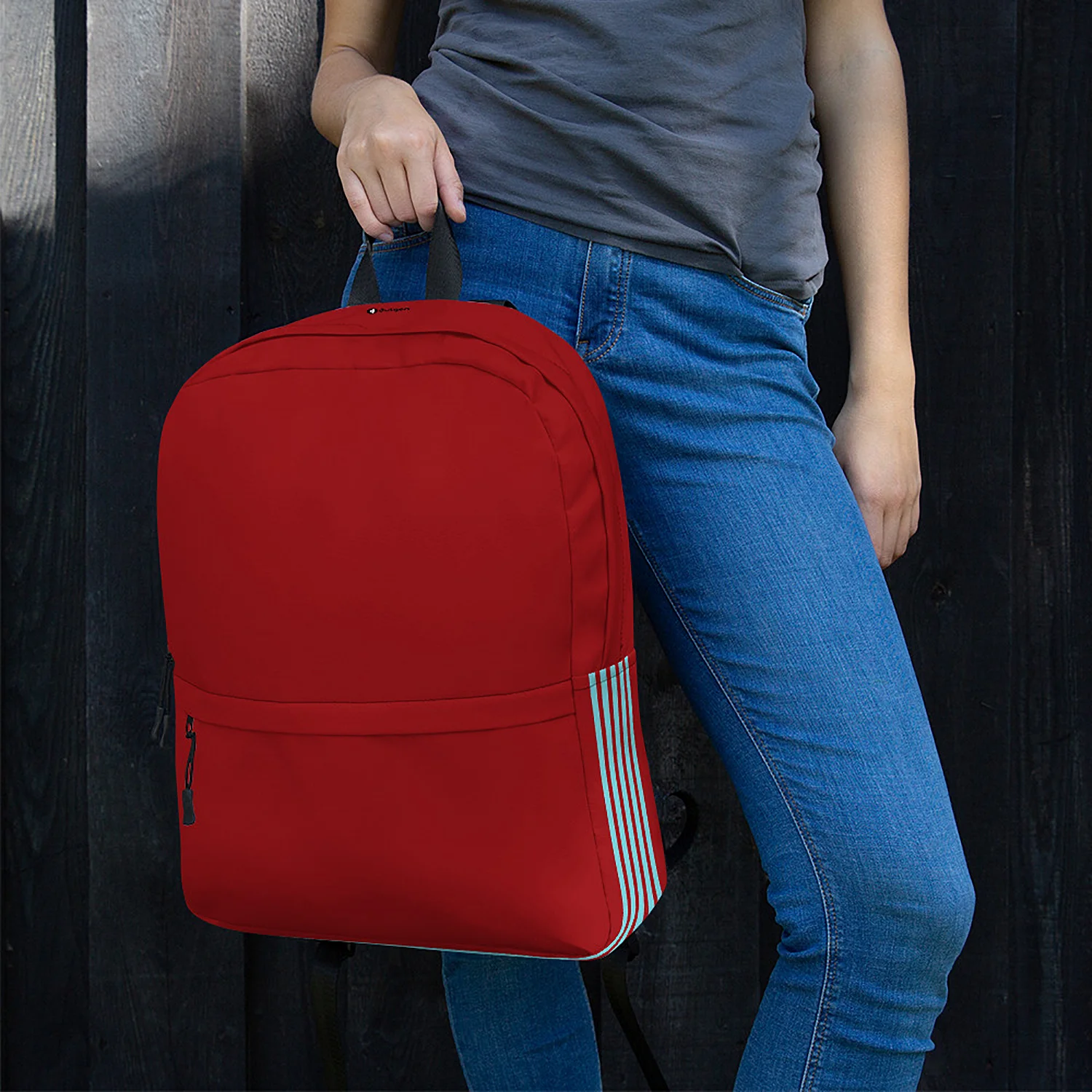 Woman carrying the Subway Urban Commuter Backpack by the top handle, showing the stripe detail.