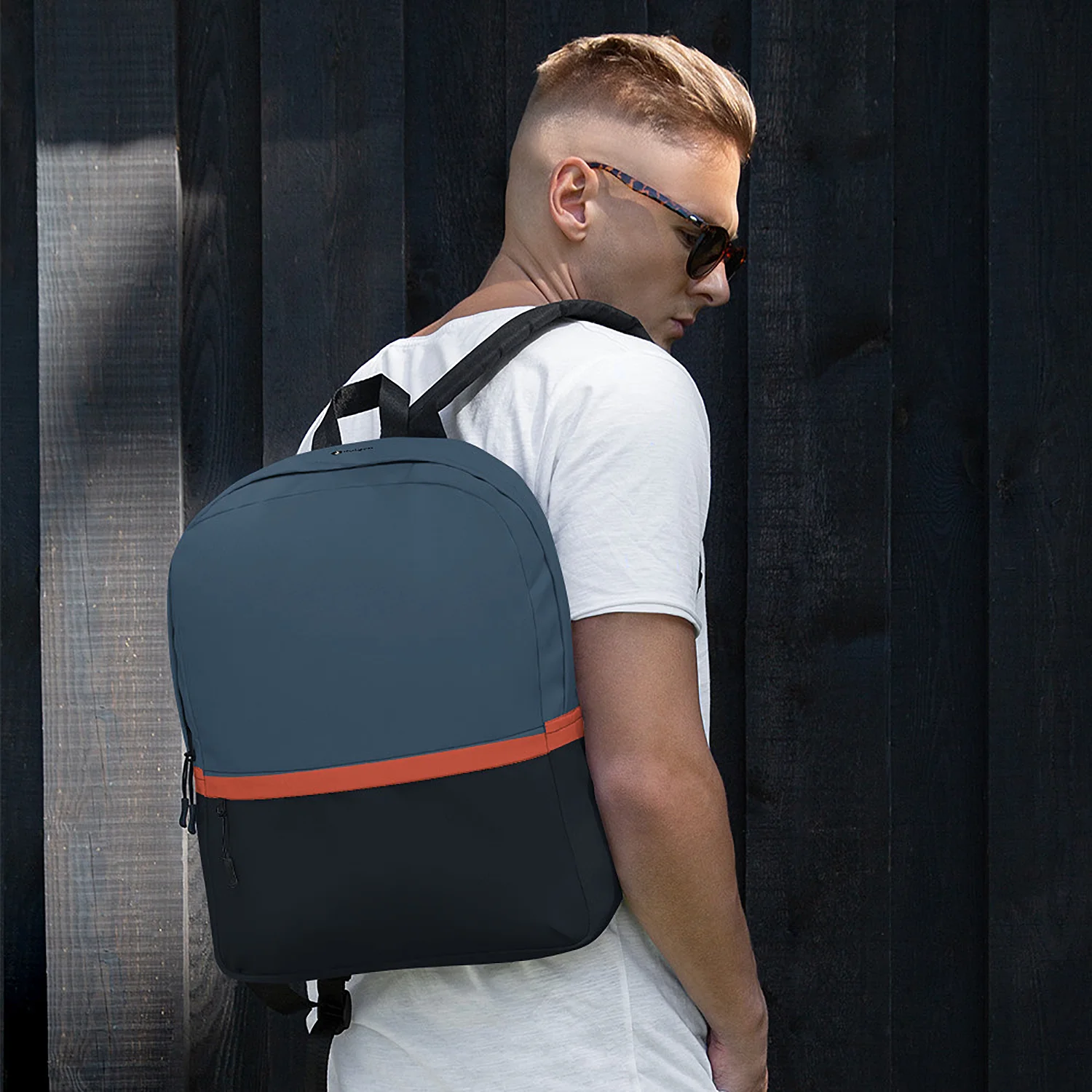 Man wearing the Tribeca Urban Commuter Backpack by dulgen™ against a dark wooden background for scale and fit.