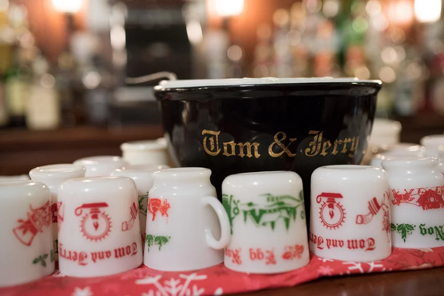 Tom and Jerry bowl and assorted mugs displayed on the bar.