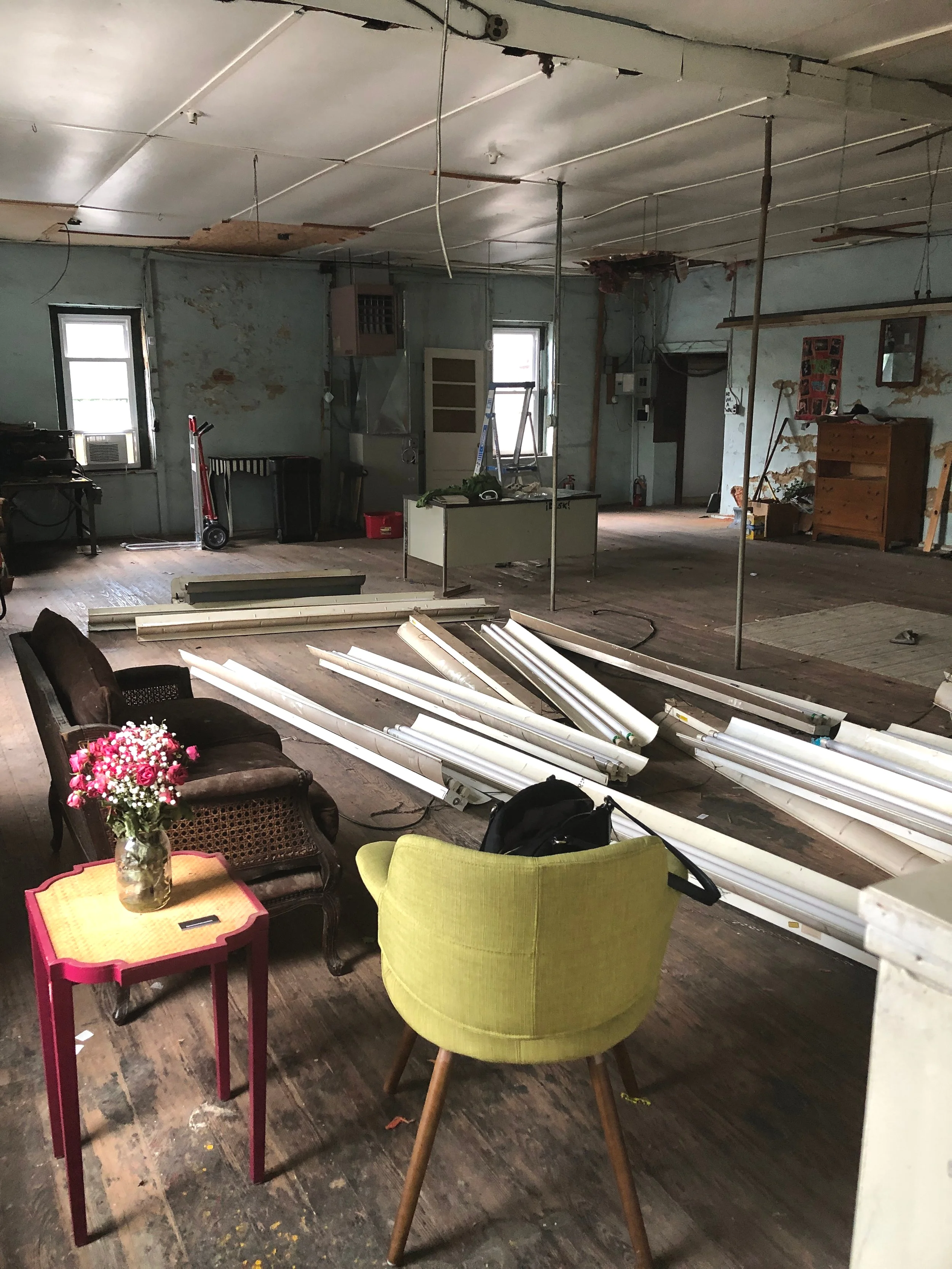 The warehouse was formerly home to an electronics distribution company. There are relics of years passed including what we believe is a printing press. It’s a mess. It’s vintage. It has good bones. There’s debris everywhere yet the space has charm. The wood floors and exposed brick are rich with character. It’s even more of a unkempt now that we took down rows and rows of fluorescent lights but I am encouraged by what I think is underneath layers of dust.