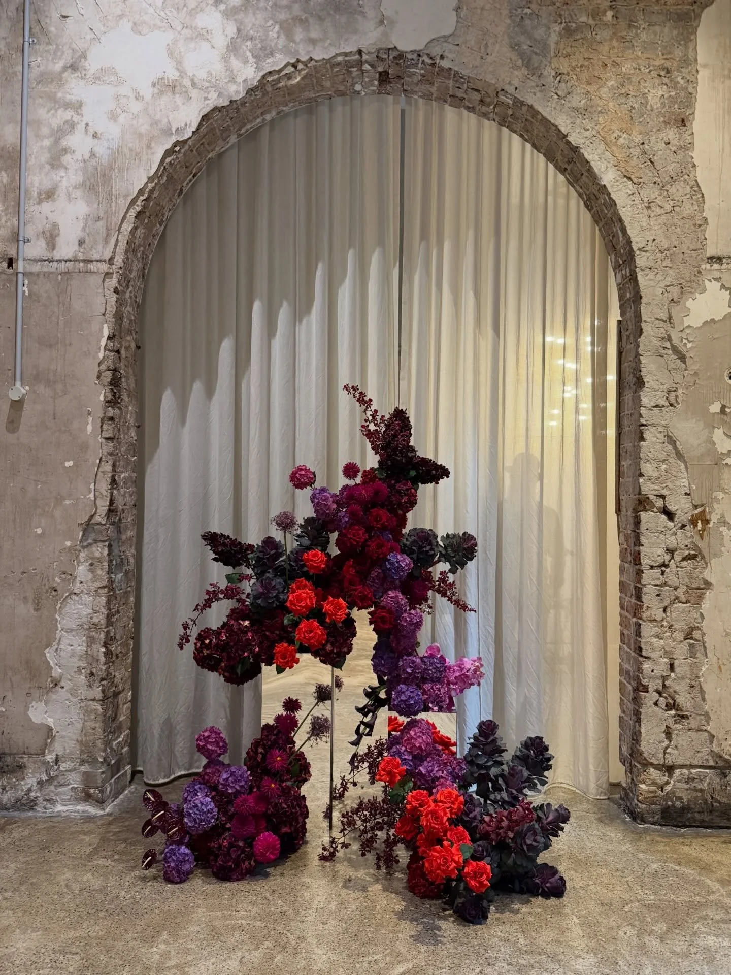 Mirror plinths + stone arches + moody yet bold gem toned flowers all adds up to a match made in heaven. Ceremony for Britt and Ben 🖤🖤🖤

My favourite part is the silhouette of the iconic @benagersydneycelebrant bowler hat hiding behind the curtain.