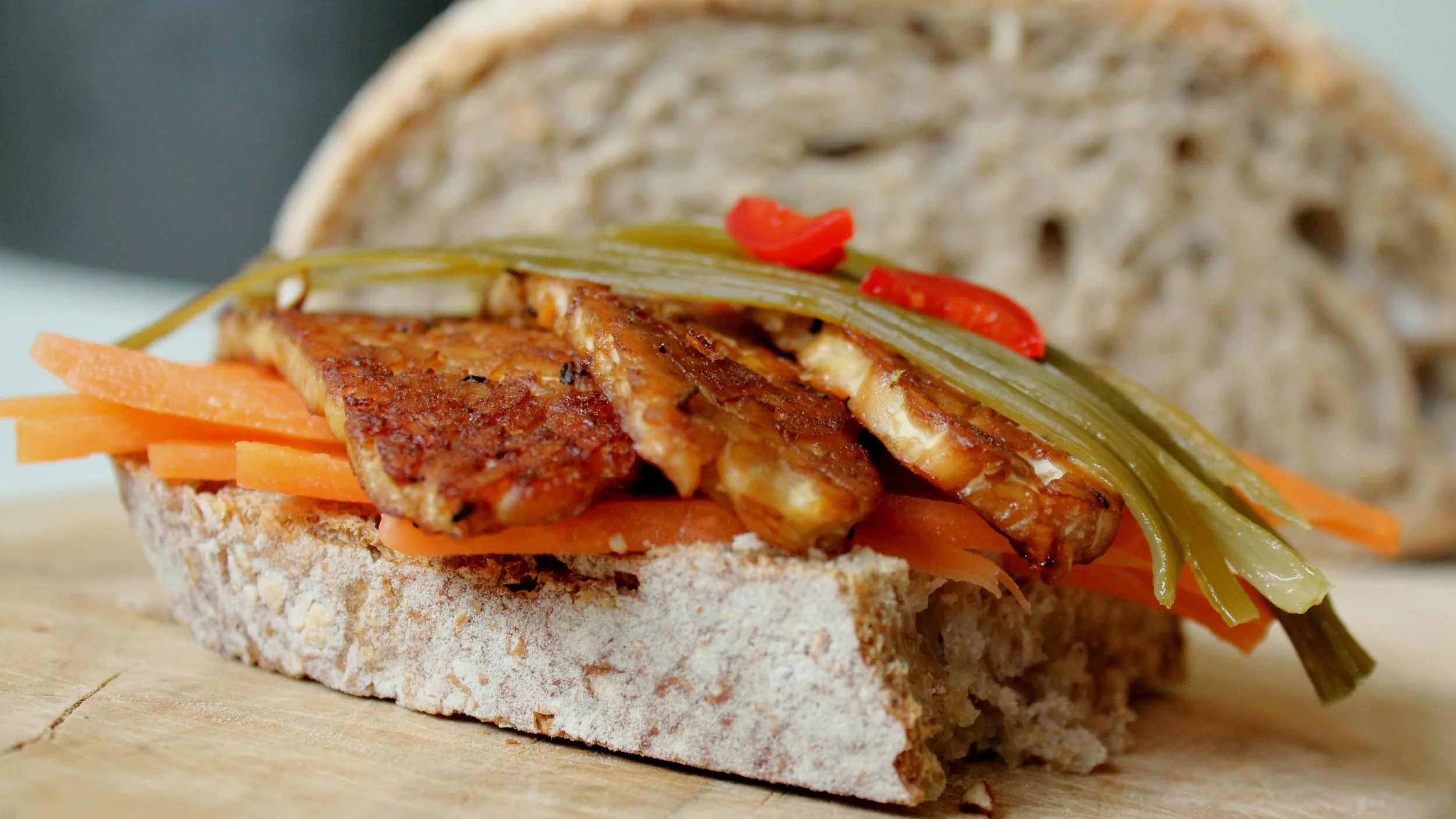 Svež kruh iz kislega testa, kisana pikantna zelenjava in mariniran tempeh.
