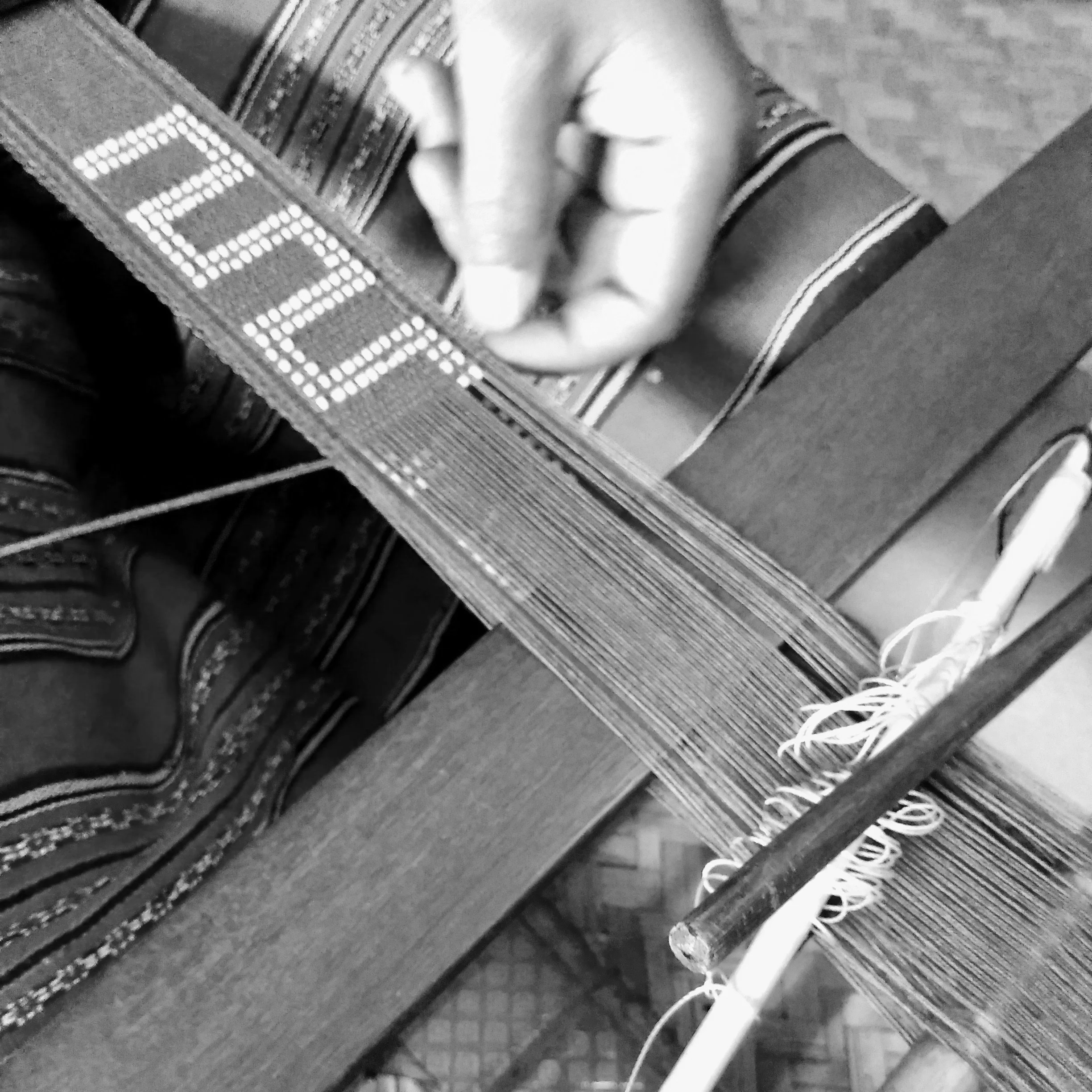 Detail of the accent beads being woven into the weft of the textile, which form the traditional motifs and designs.
