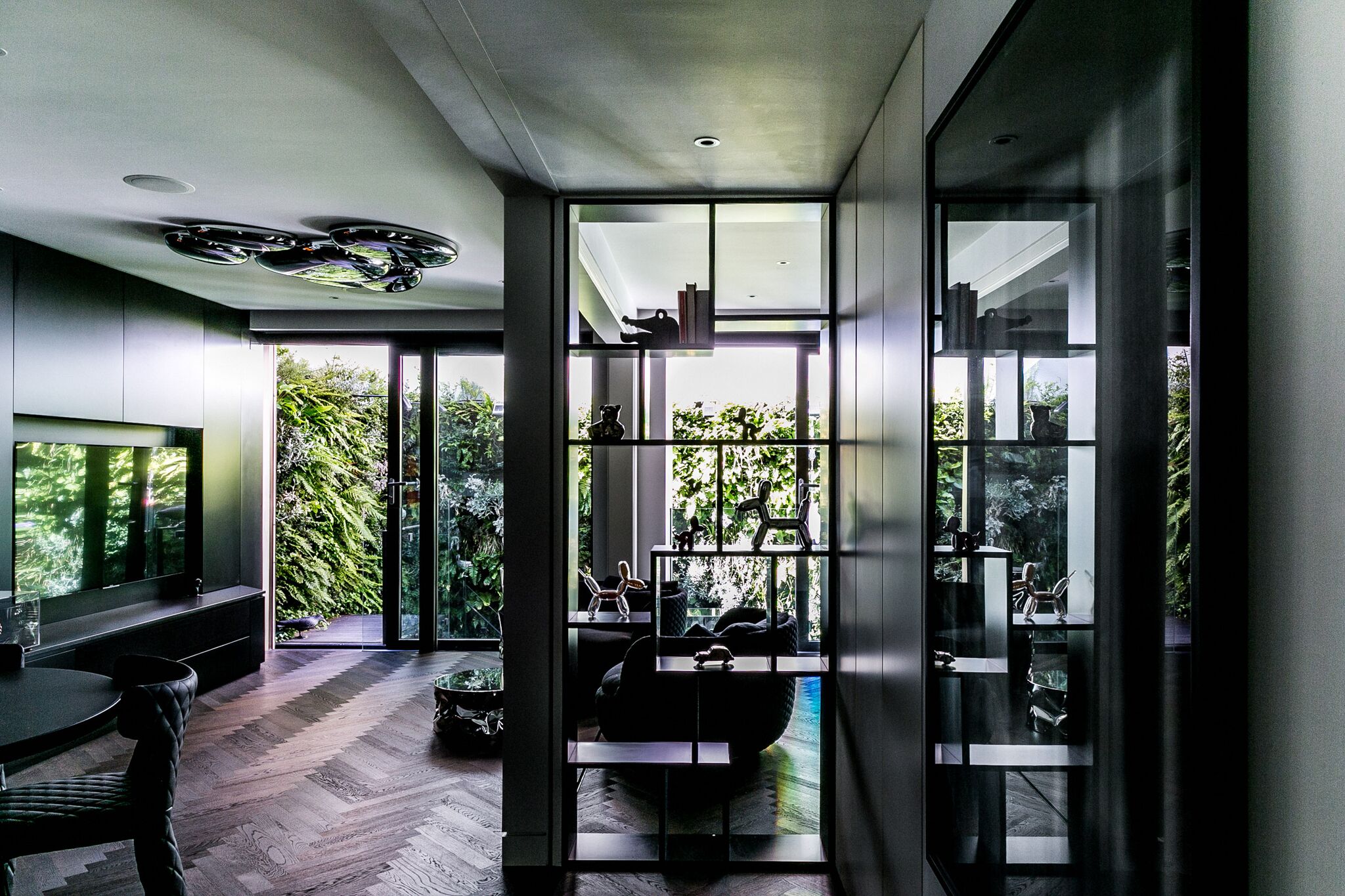 At ground floor an open plan kitchen, dining and living area with custom built-in furniture comprise the ground floor. Large sliding doors provide views to the garden. 