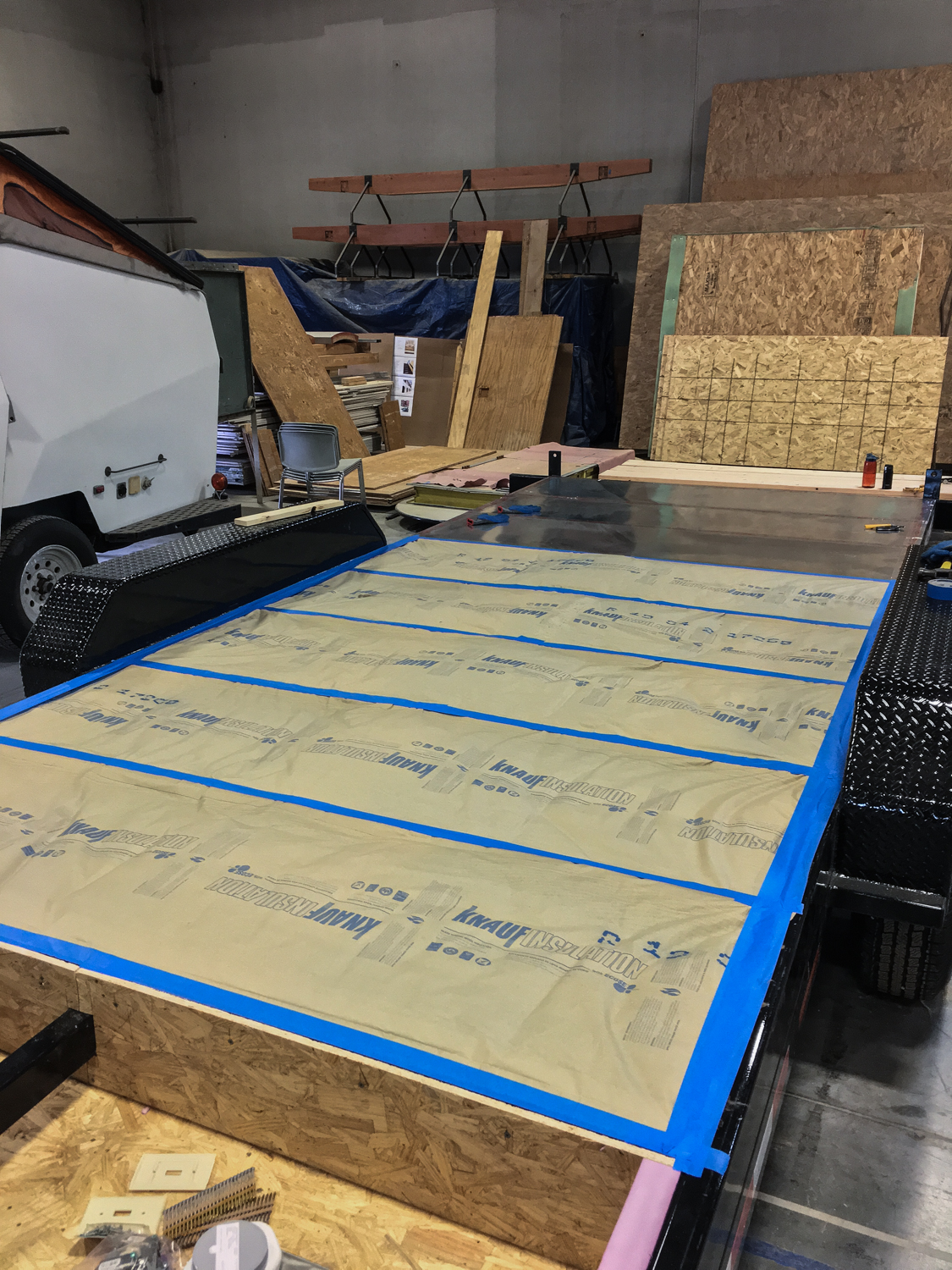 Front end of trailer flashed on bottom, with insulation on top. Raised floor system with storage will be installed on top of insulated zone.