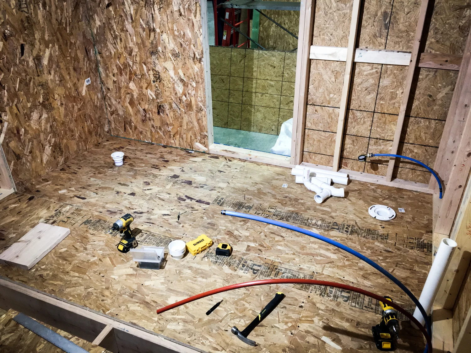 Plumbing connections. Top left corner: shower drain. Top right corner: toilet water supply and drain. Bottom right: washer water supply and drain.