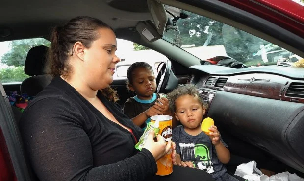 Jennifer Parker feeds snacks to her sons,Tristen, 4, center, and Amarion, 2, right, in their car in Gilroy, Calif., on Monday, August 14, 2017. Jennifer and Ashante Parker couldn’t make rent on their Modesto apartment after Ashante suffered an injury to his back. They have lived out of their car for the past few months with their three young children. (Gary Reyes/ Bay Area News Group) 