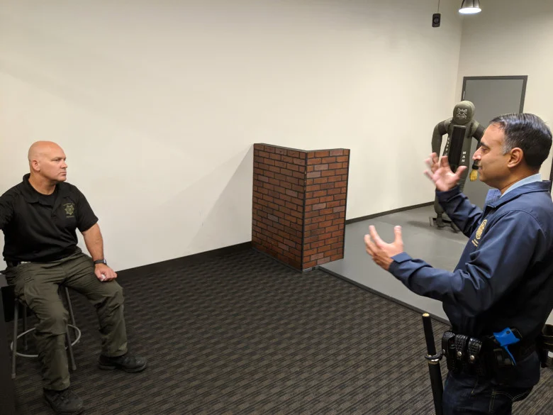 Assemblyman Ash Kalra, D-San Jose, right, is debriefed by San Jose police Officer Theodore Davis, left, during a session with the department's force-option simulator at the SJPD substation in South San Jose on Aug. 17, 2018. (Robert Salonga/Bay Area News Group)