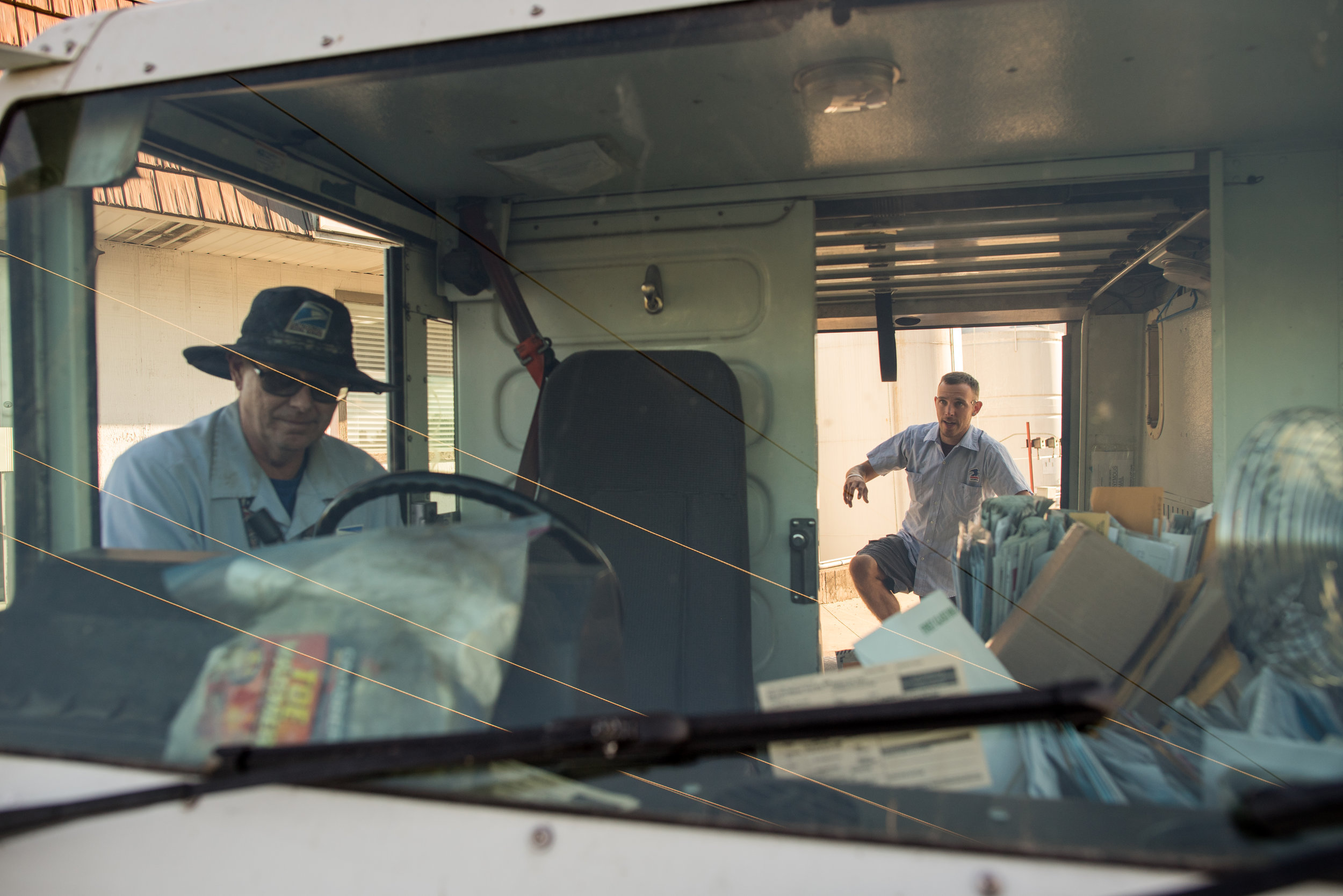  Lee Krueger, steps into the back of the mail truck. Lee joined Greg to learn the route.&nbsp; 