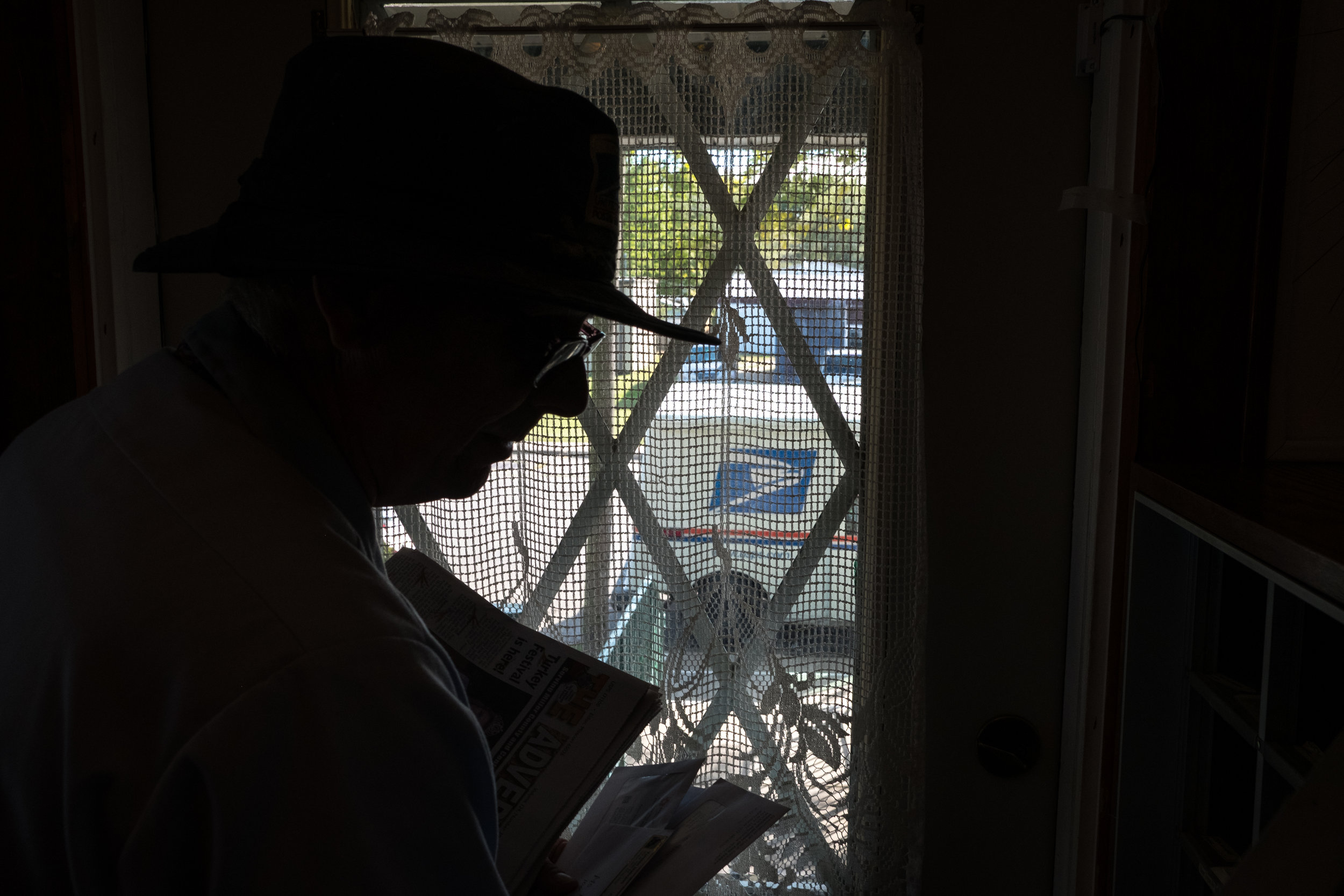  Greg putting mail into the lock boxes at Lee House, an assisted living complex. After dropping off the mail, Greg walks through and visits with the residents.&nbsp; 