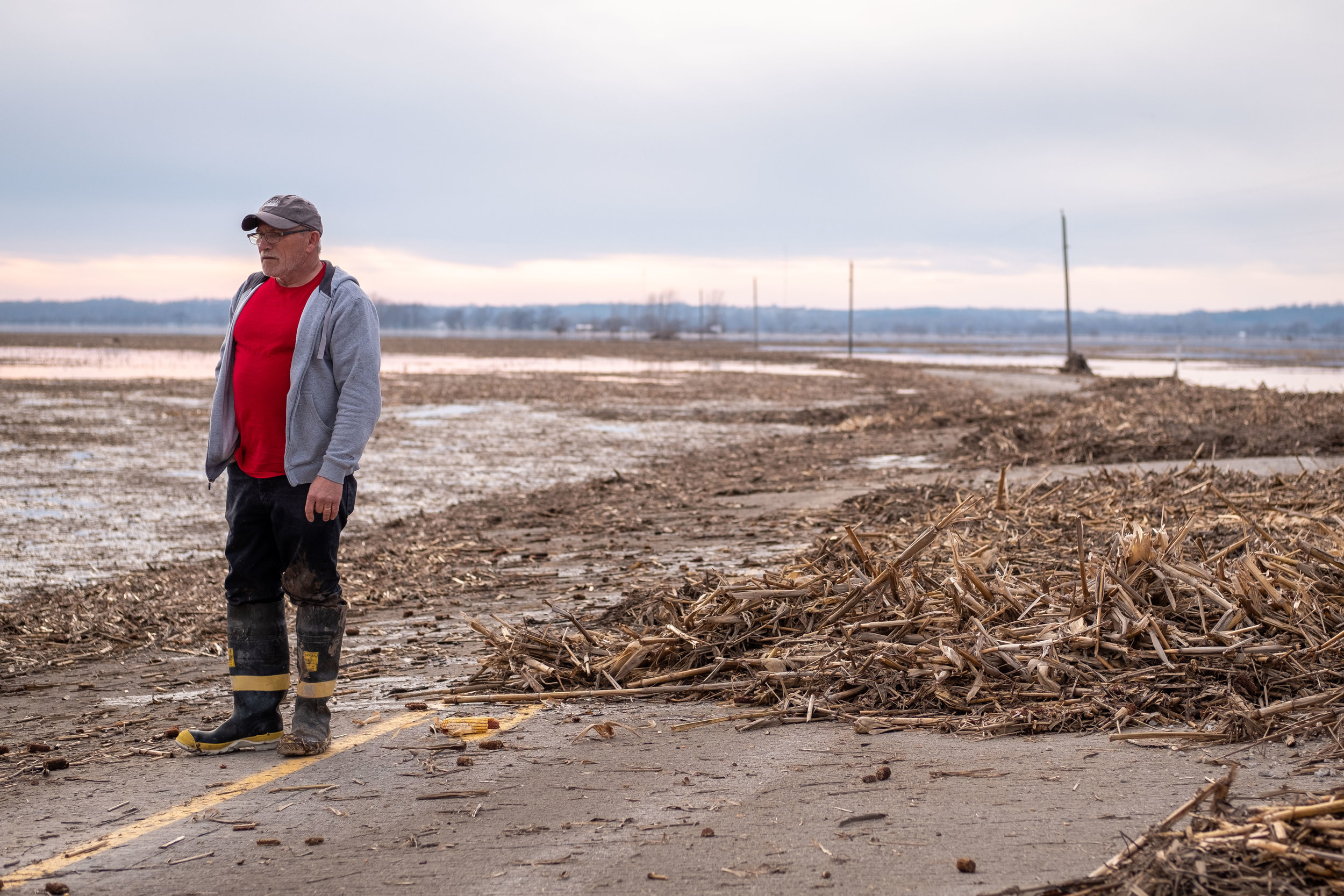 Dean Doty stands on the impassable road to Bartlett Iowa. Doty's home can be seen several miles to the west.