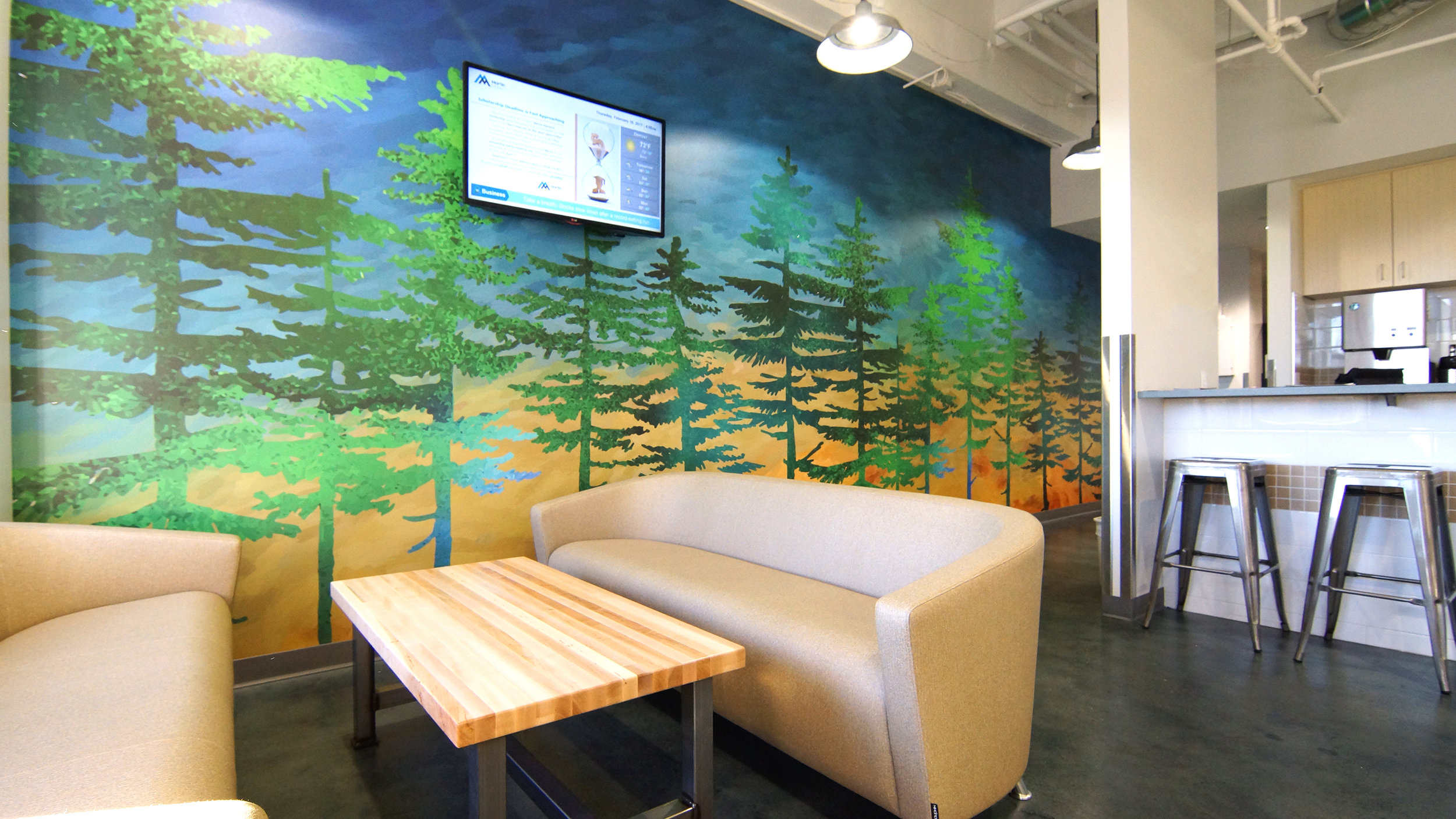 This customized, colorful wall graphic incorporates brighter colors to complement the overall color palette and help infuse a bit of stylized nature into the break room.