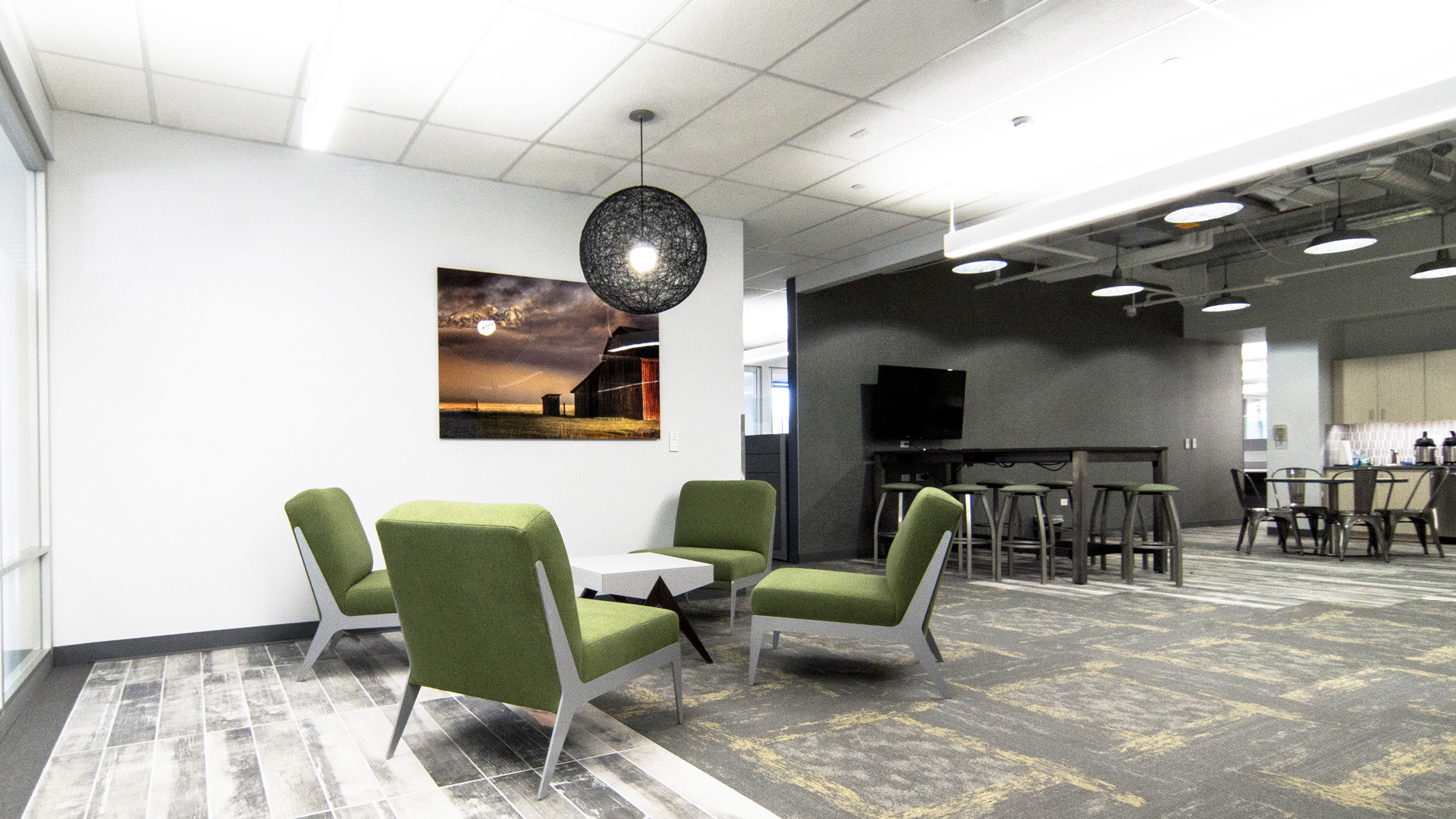 Initially, the Daltile Yorkwood Manor floor tile was used in a somewhat limited manner. However, Martin Marietta liked the product so much, we decided to expand its application to include the executive lounge and aisle in front of the executive offices. Another important design requirement for the project was a variety of meeting spaces, both open and closed. The above image shows both a soft, lounge huddle area and a standing height table with integrated power and unique lighting provided by Visual Interest .
