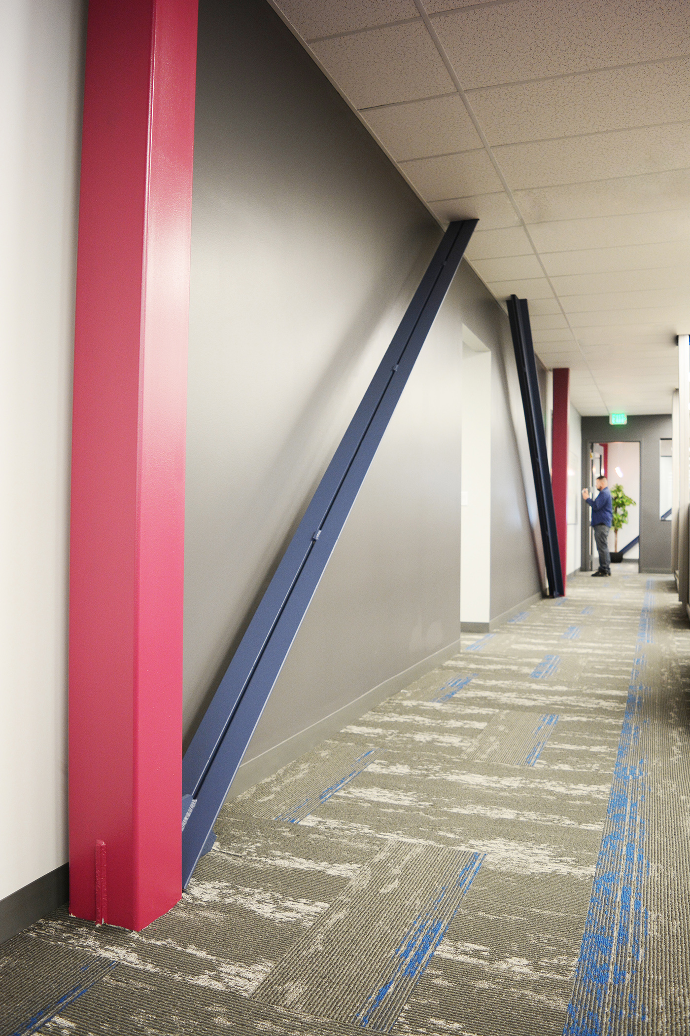 Throughout the office space structural columns and bracing were left exposed and branded with Alpha's colors. The diagonal lines of the bracing and high chroma colors created a more engaging and dynamic space.