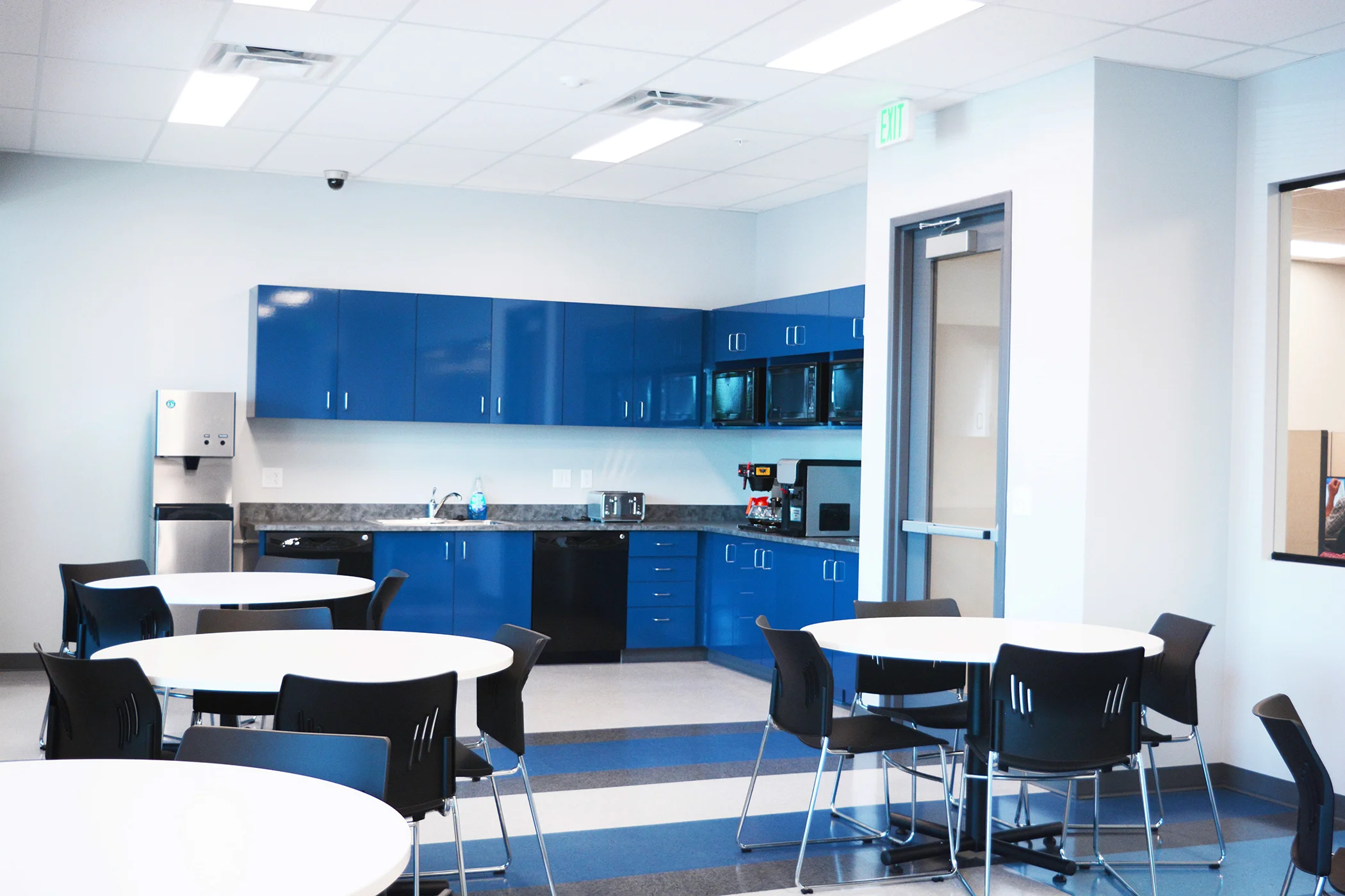 We used high chroma Formica gloss laminate on the millwork in the breakroom, copy area and executive coffee bar. Vertical and horizontal surfaces mimic the VCT patterned flooring, which features 5 different colors in blue and grey tones.