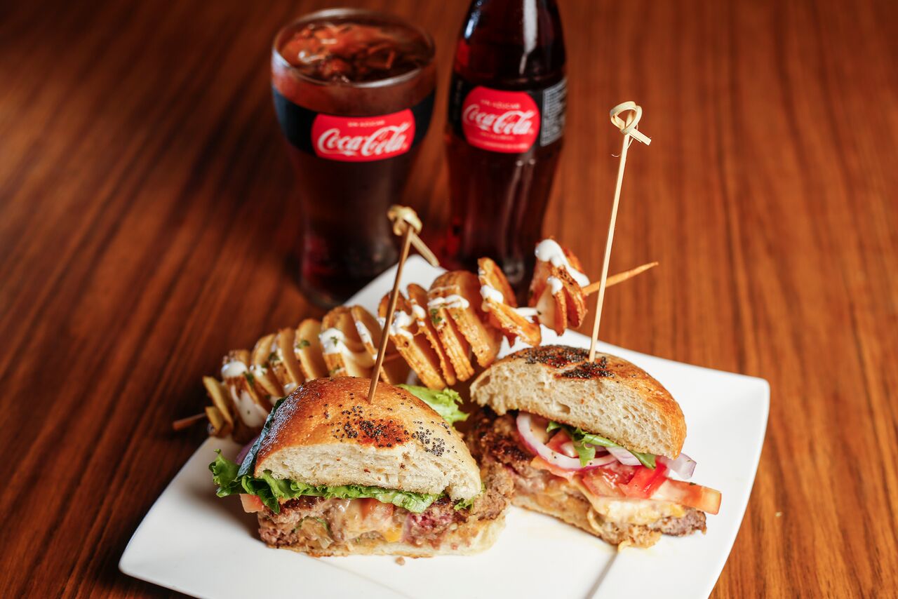 RESTAURANTE LA CASCADA Ricardo Wasserman, propietario y nieto de don Guillermo Pérez y doña Flor Lizano, fundadadores del restaurante La Cascada, con una trayectoriade más de 50 años en Escazú. #QUEEN Es una Juicy Lucy en pan brioche artesanal, con 100% carne angus ysazón propio de nuestra cocina, salsa bohemian, tomate, lechuga y cebolla morada, acompañada de papa en espiral con salsa ranch.