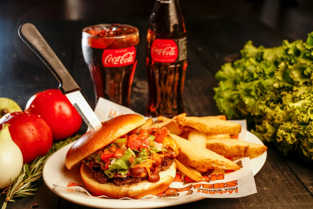 Hooters Costa Rica Chef Marlon Masis, MBA y Empresario. Amante de la gastronomía, experto en restaurantes, ha sido operador de las categorías casual, sport´s bar, fast casual y comida rapida. #WANTEDDEADORALIVE 8 onzas de jugosa carne, cubierta de queso cheddar derretido, nuestra deliciosa receta de chili con carne, lechuga, pico de gallo fresco y una única combinación de salsa ranch con nuestra salsa insignia Hot, todo esto en medio de pan artesanal brushes.