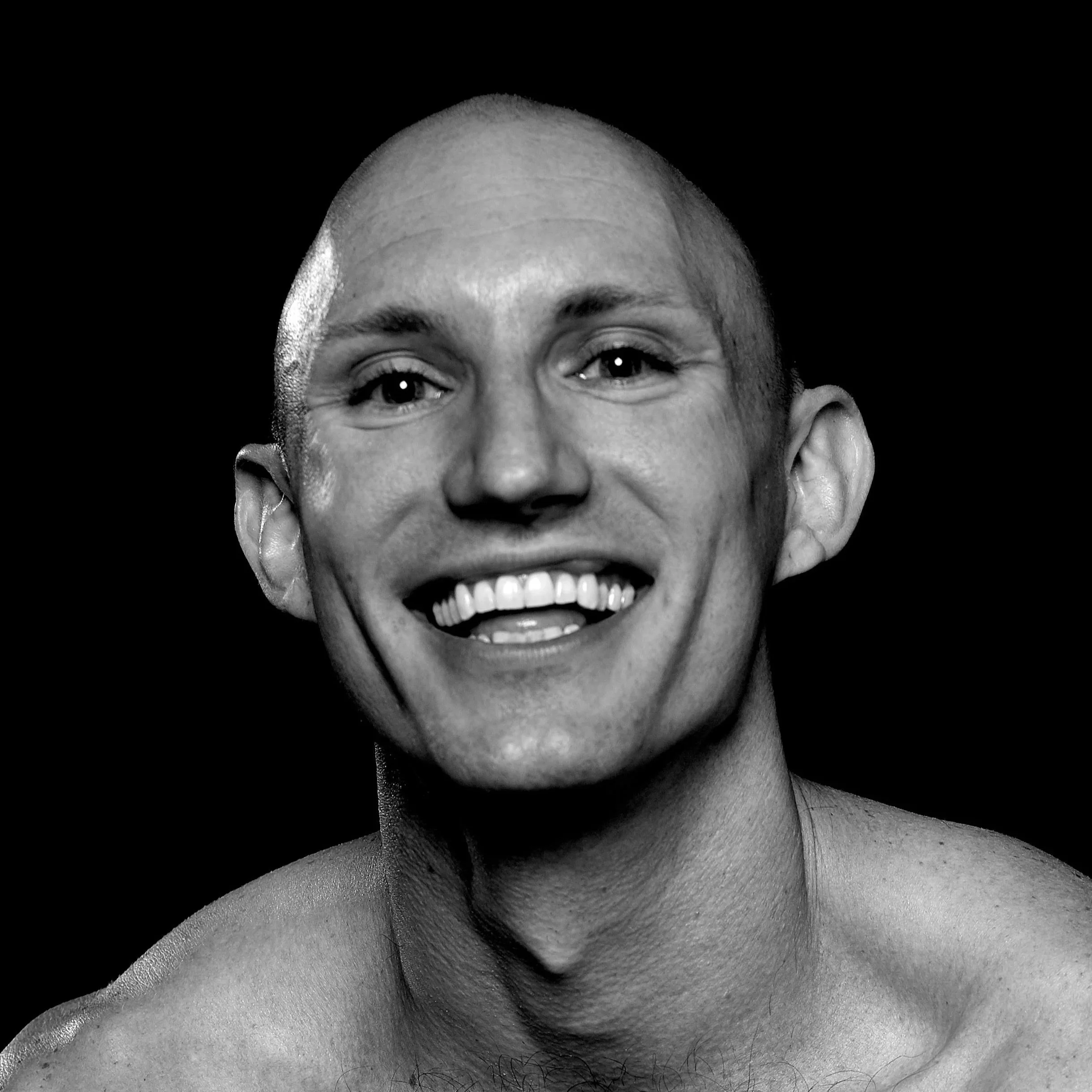 Portrait black and white image of Cody looking directly at the camera with a big smile.