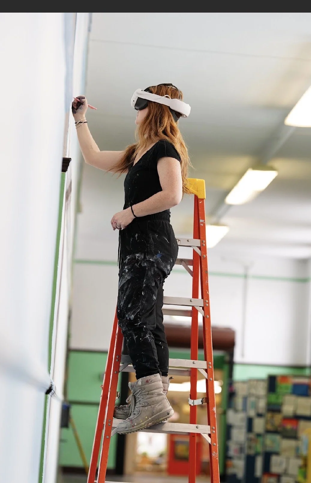 Ryan Tova Katz wearing Meta Quest goggles while painting a mural at Nettlehurst Elementary School in Chicago, IL