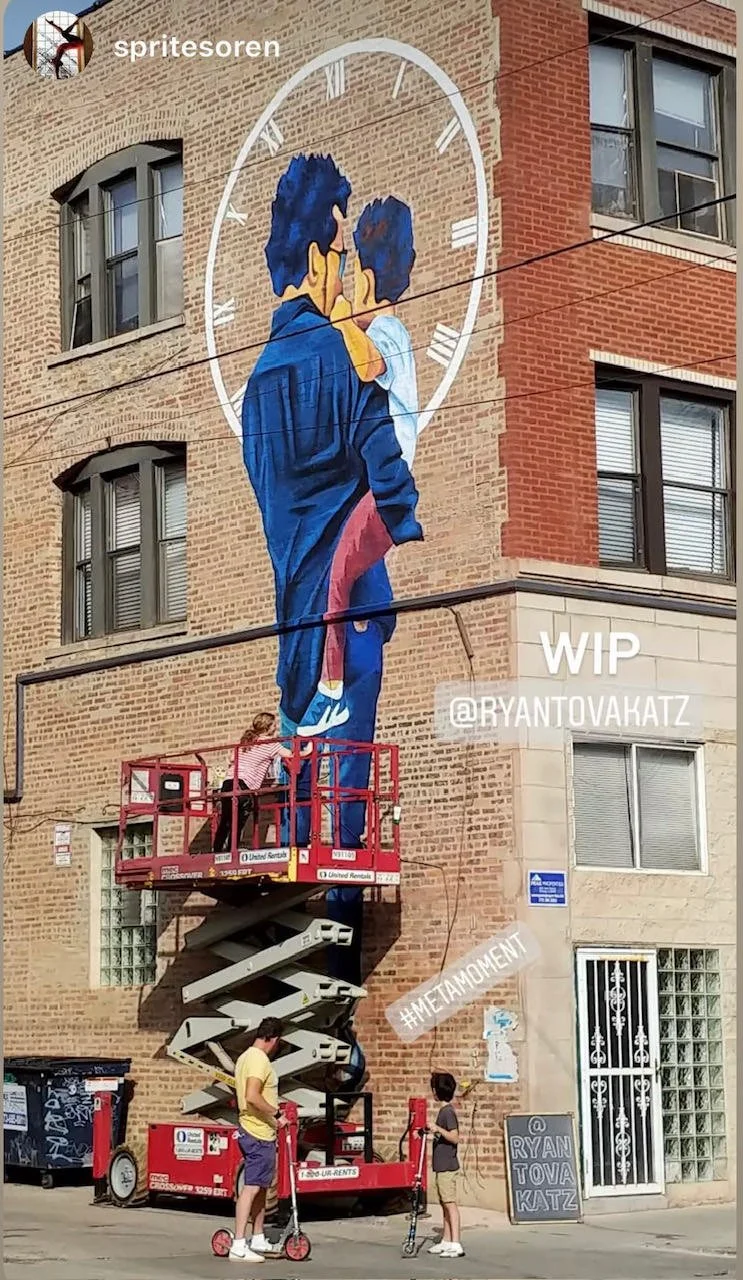 Ryan Tova Katz painting a mural on a brick wall in Chicago, IL, using a lift