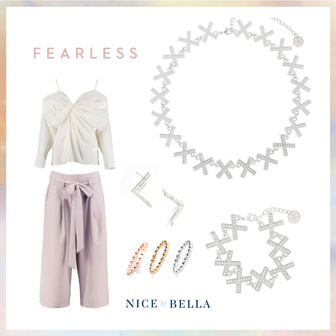 Demonstrate fearlessness in these lavender trousers and off-white, strappy blouse. It’s paired with crystal encrusted, rhodium earrings, bracelet and necklace. A pop of color is shown with a trio of rose gold, gold and rhodium rings. SKU’S: 118041L, 118049L, 118123, 118497