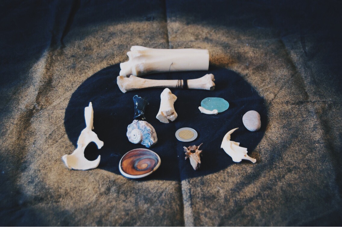 My own bone throwing set. The cloth I’ve created for them is simply a black handkerchief with gold spray painted on it.