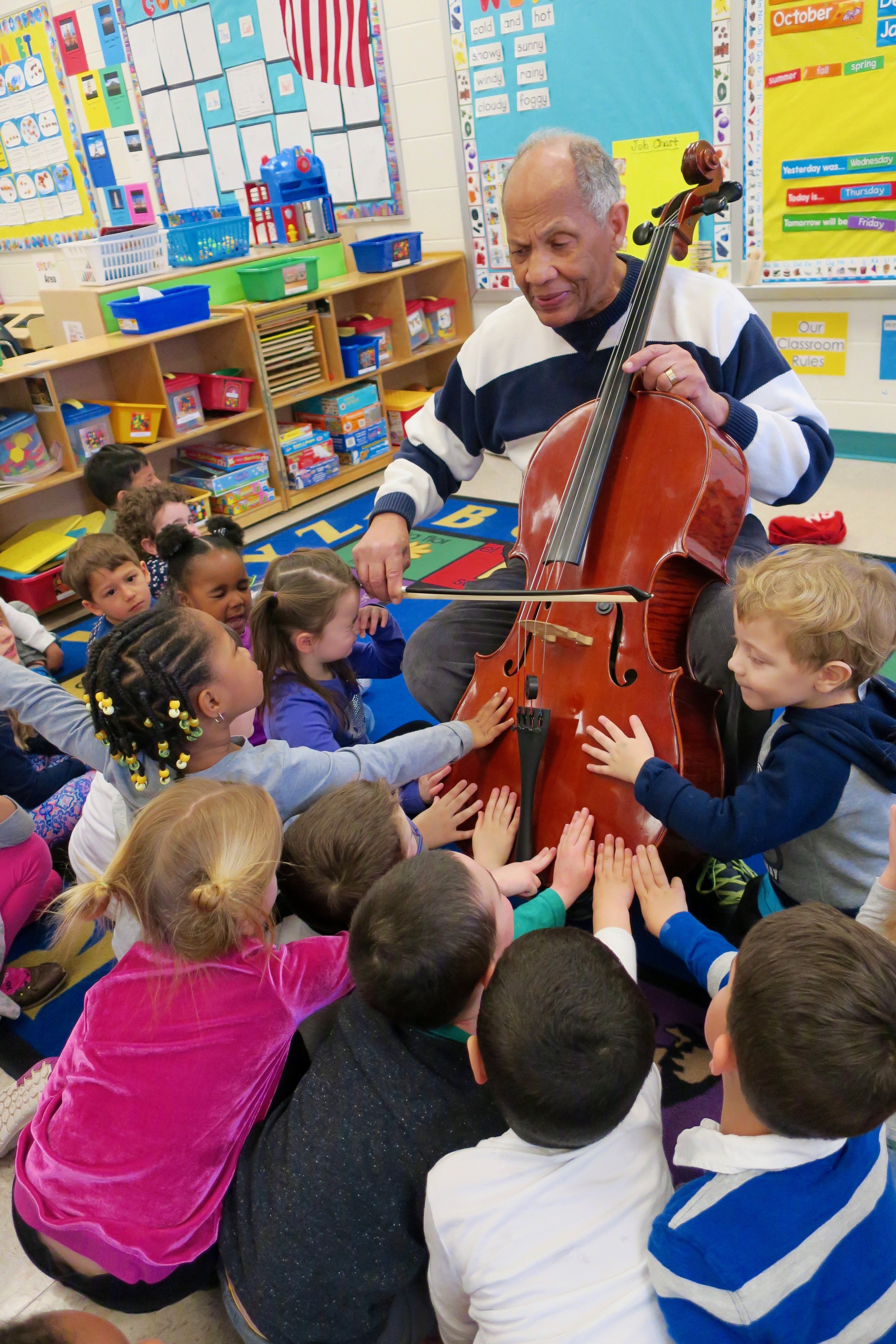 DC Strings Member Ray Pitts shares a moment with local elementary school children - sharing the joys of music and introducing them to the cello!