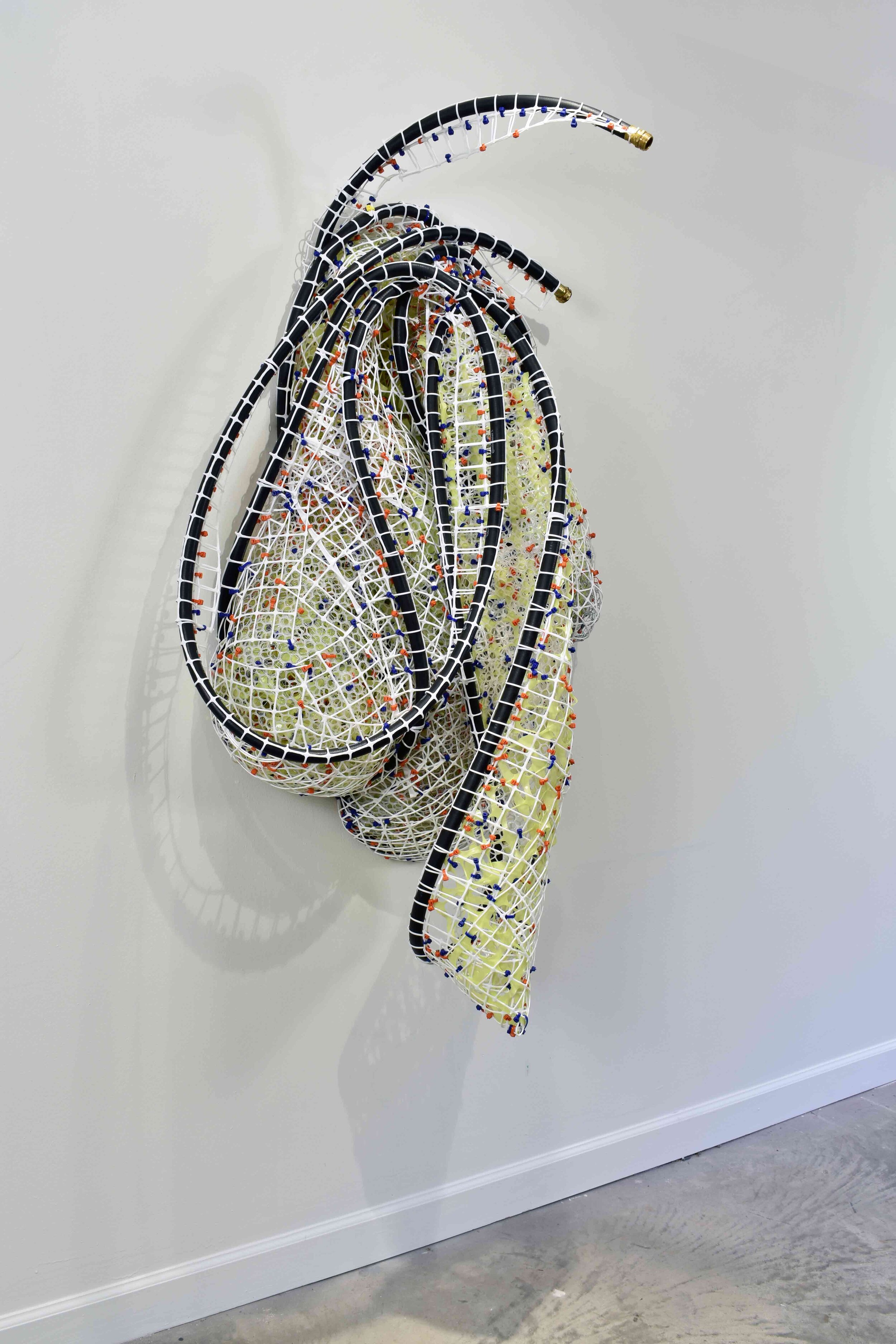   Kryptonite Hose_1   2019  plastic and metal fencing, cable ties and rubber hose  60 X 32 X 19”  Private Collection 