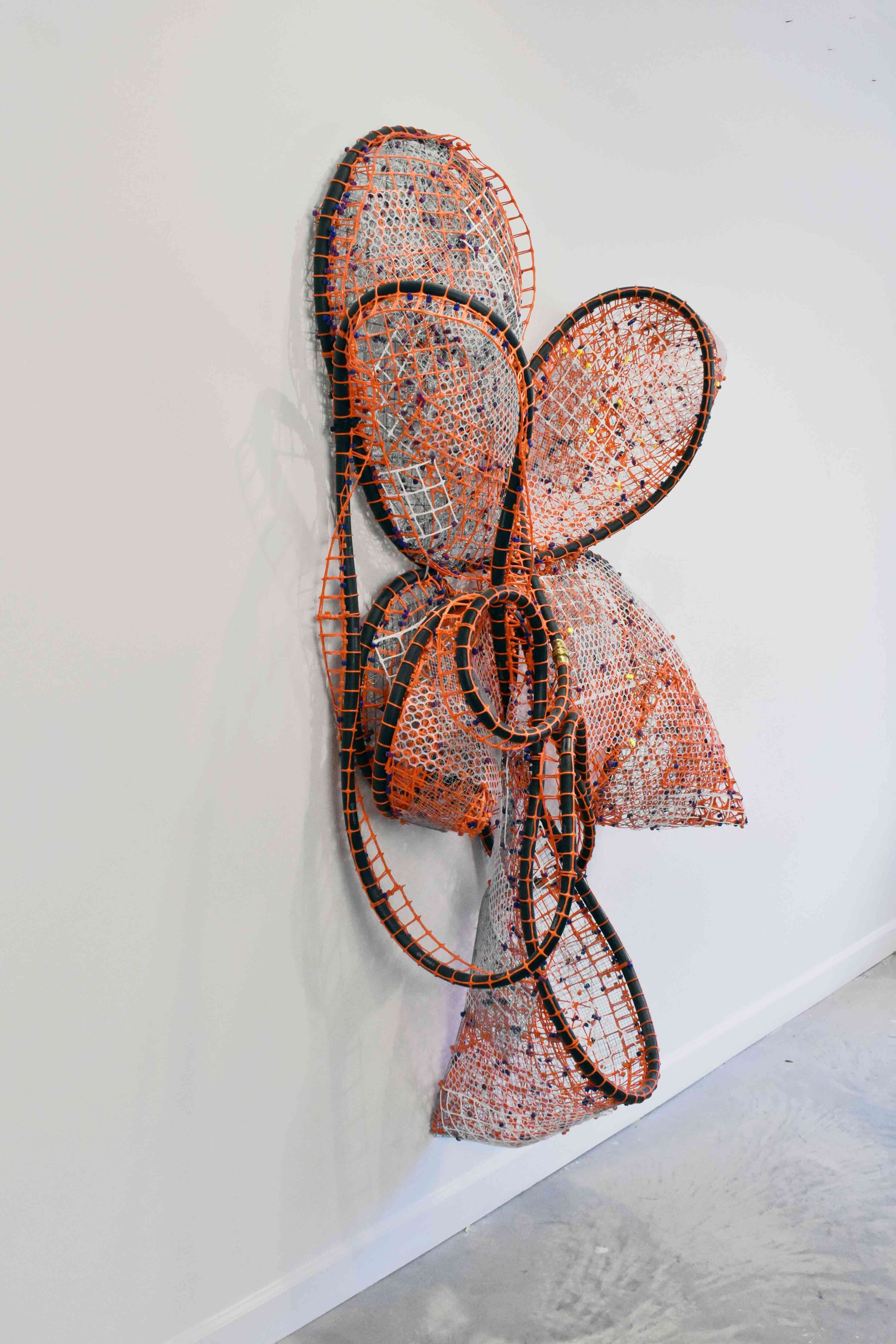  Black Hose #2_orange_white  2019  plastic and metal fencing, cable ties and rubber hose  60 X 55 X 20” 