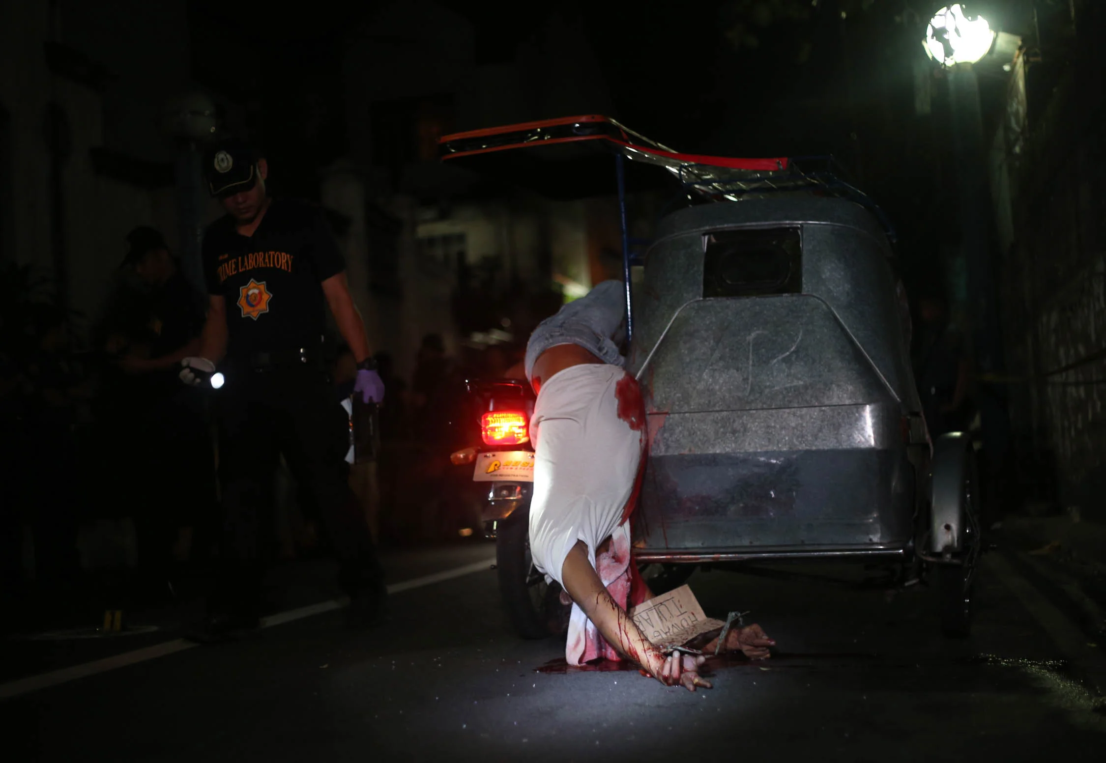 Alleged drug pusher Redentor Manalang is found lifeless on his tricycle after being shot and killed by riding-in-tandem suspects in Protacio St, Pasay on July 23, 2016. 
