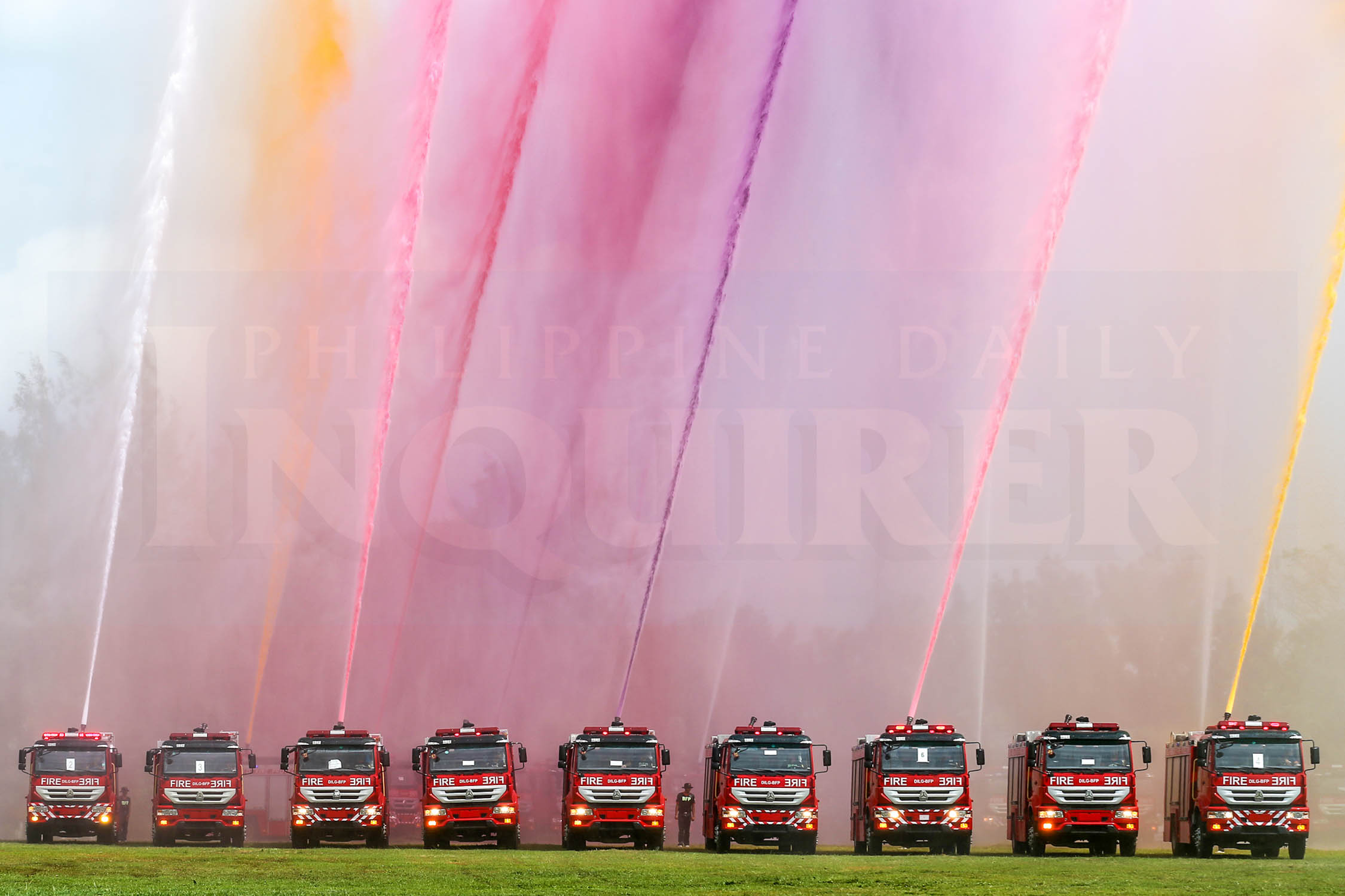 New firetrucks show their capabilities by blasting colored water in the air in Camp Vicente Lim, Calamba Laguna province on August 7, 2015. The distribution of 80 1000-gallon firetrucks to different municipalities is the first batch of 469 DILG-BFP firetrucks to be distributed nationwide.