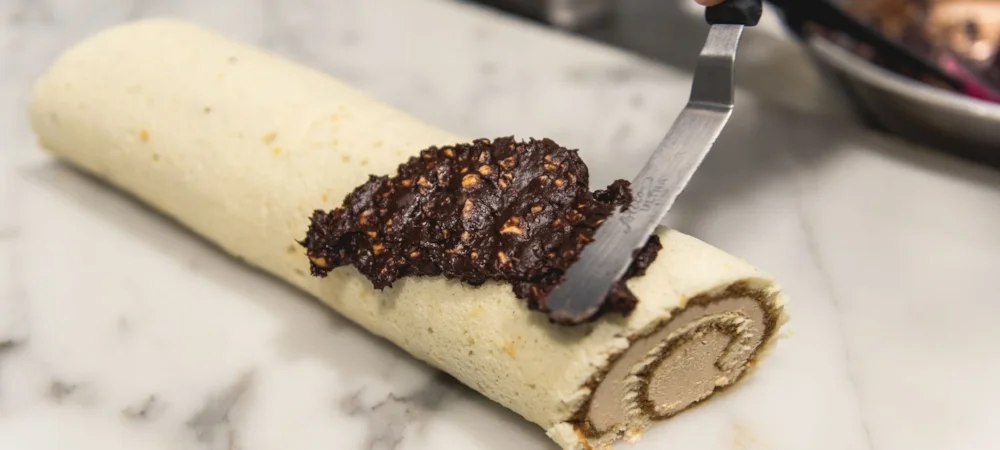 Spread the ganache over the cake evenly and create patterns using a flat edge knife. 