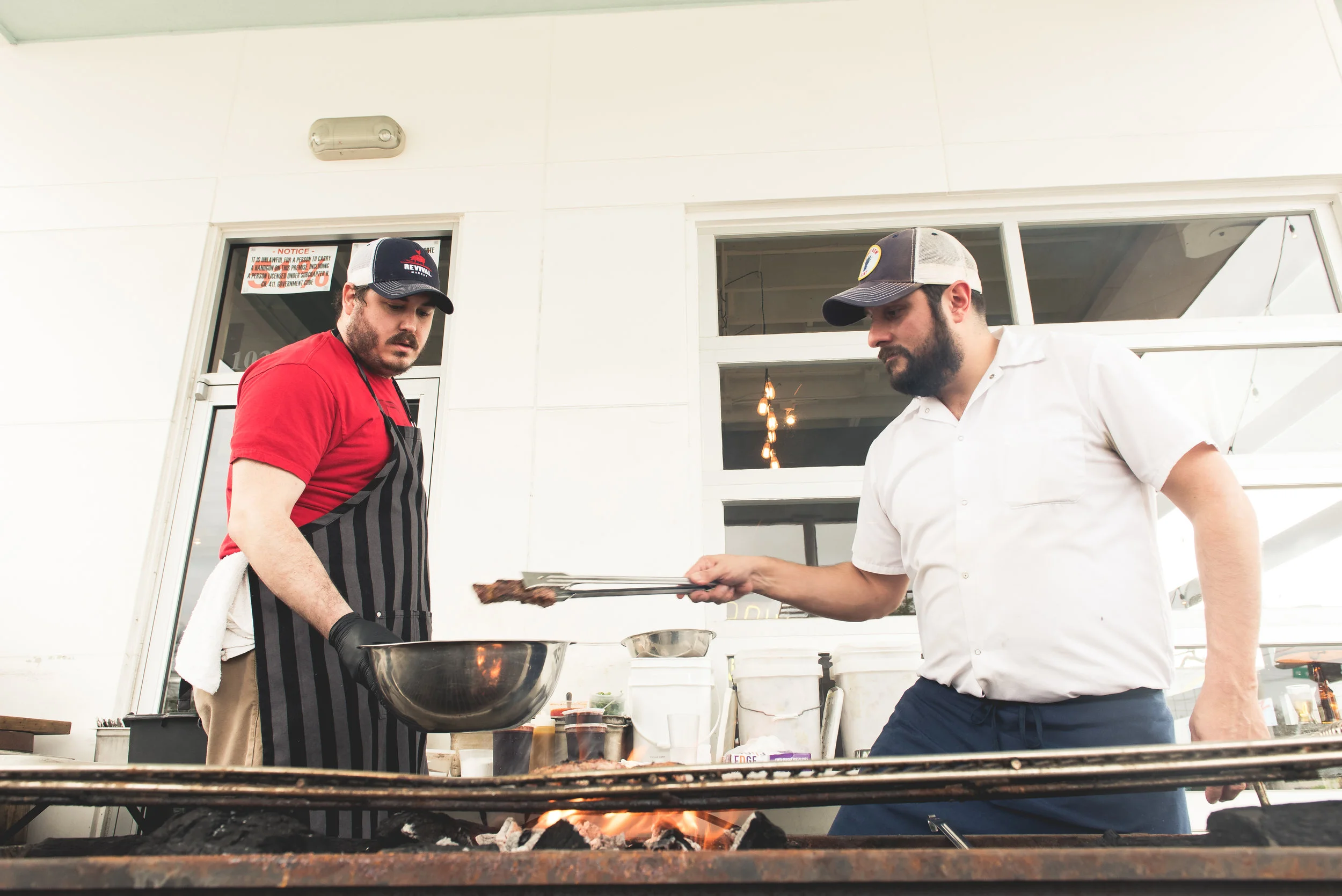 Revival Market's Todd Patterson and Marcelo grilling ribs