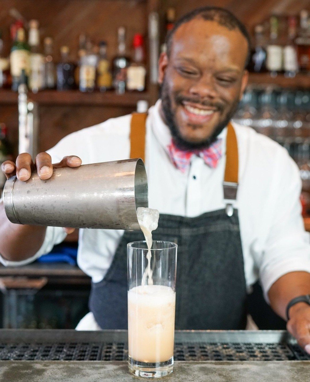 Pictured here, @gregory.d.thompson pours up The Lunchbox Surprise, a cocktail created by our lead bartender, Becca, which includes spiced rum, pineapple, lime, a berry tea infusion and is topped off with ros&eacute; bubbles. Being an avid tea drinker