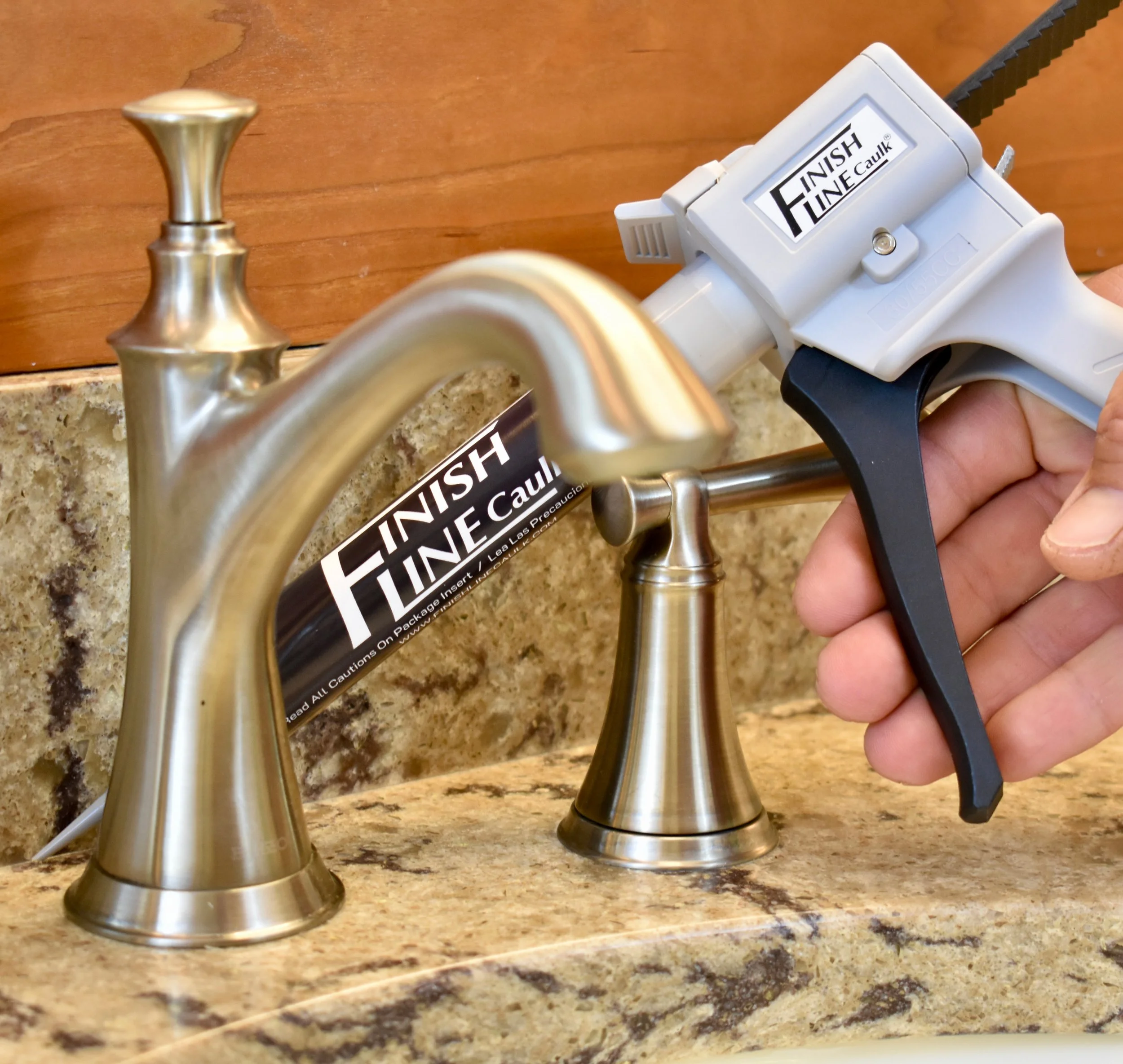 Finish Line Caulk 55 mL hand dispenser applying off-white sealant to interior window trim for a clean, controlled bead in a tight corner.