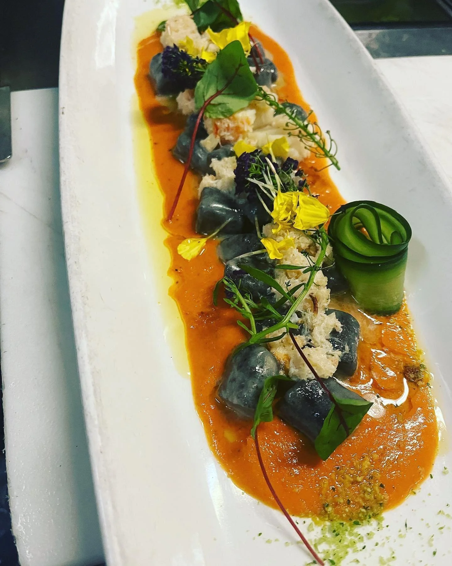 Squid ink gnocchetti served on a bed of crab-cognac bisque and Dungeness crab 🦀 meat and micro sorrel