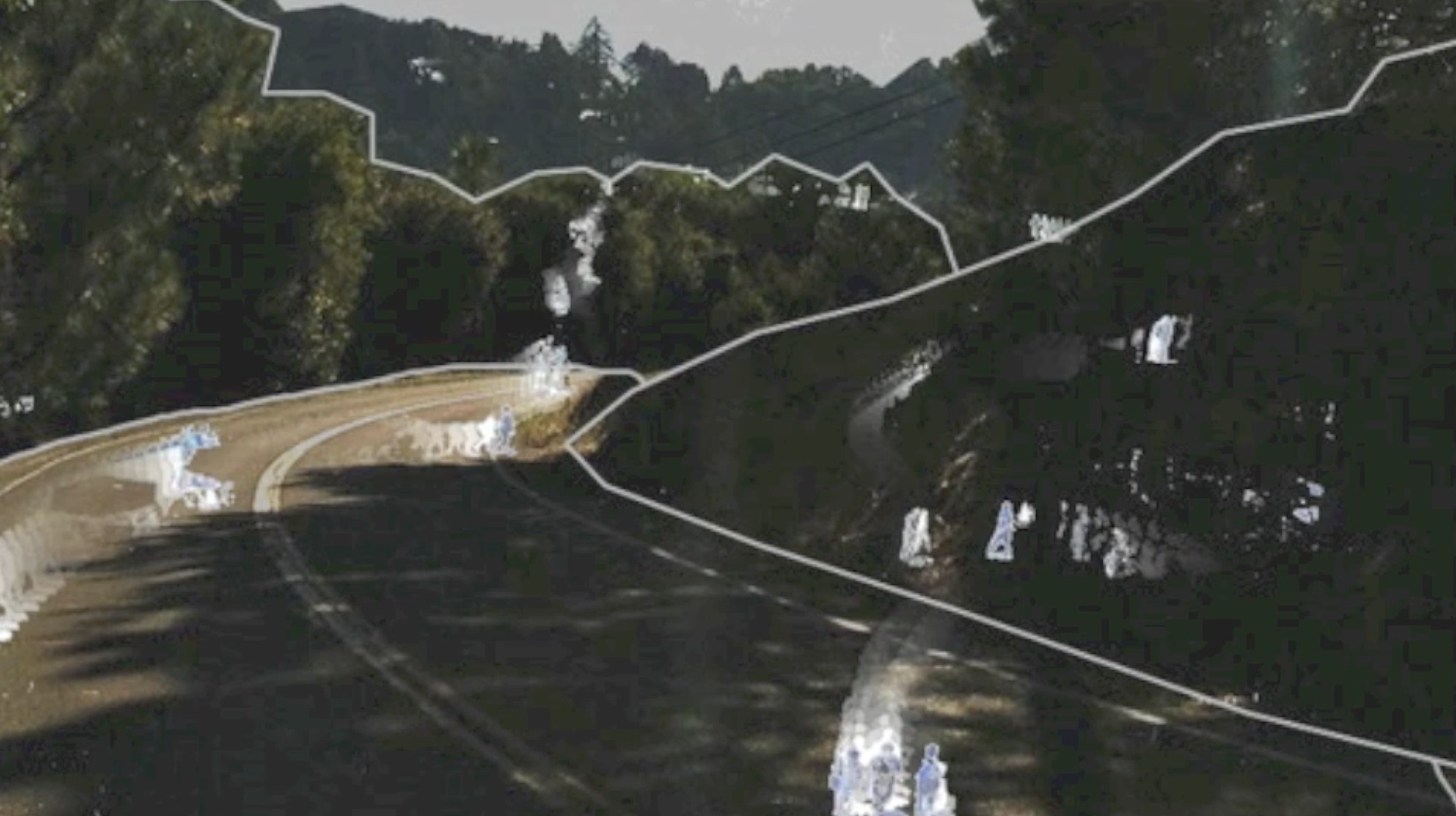 A winding mountain road lined with trees, with visible white outlines highlighting the road's boundaries and slopes.