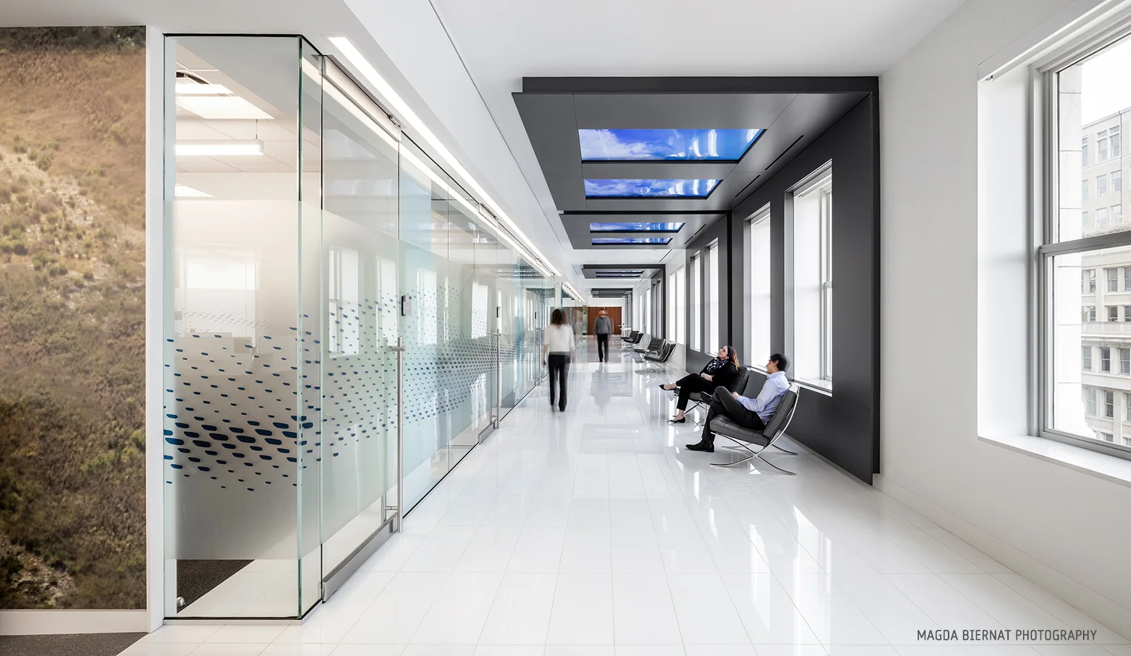 Traveling between the showcase and collaborative workspace, visitors walk the Skywalk Corridor. Ten windows line the ceiling, each with high-resolution motion graphics that evolve from the daytime Contrail view which tracks flight patterns, to Galax…