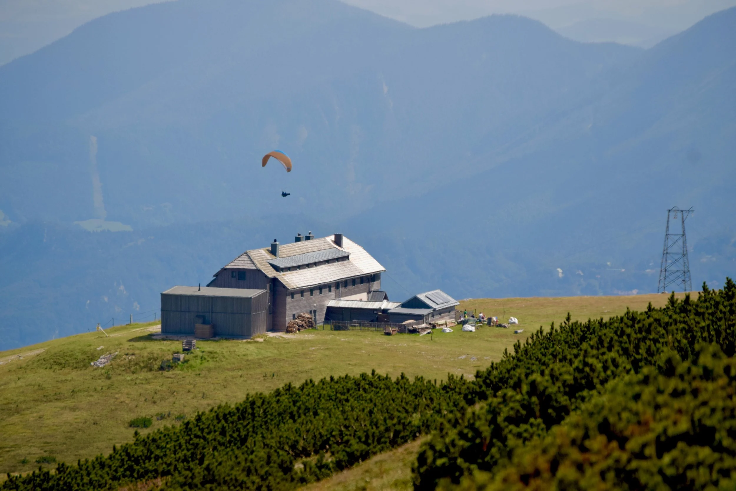 A paraglider flies above the Karl Ludwig Haus | Max Ritter
