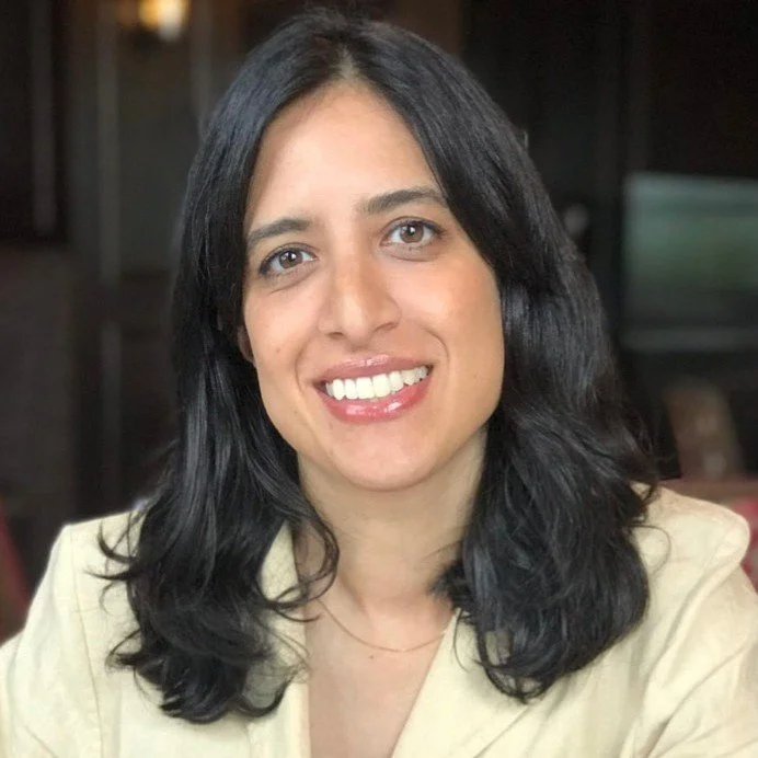 Smiling person with long dark hair indoors